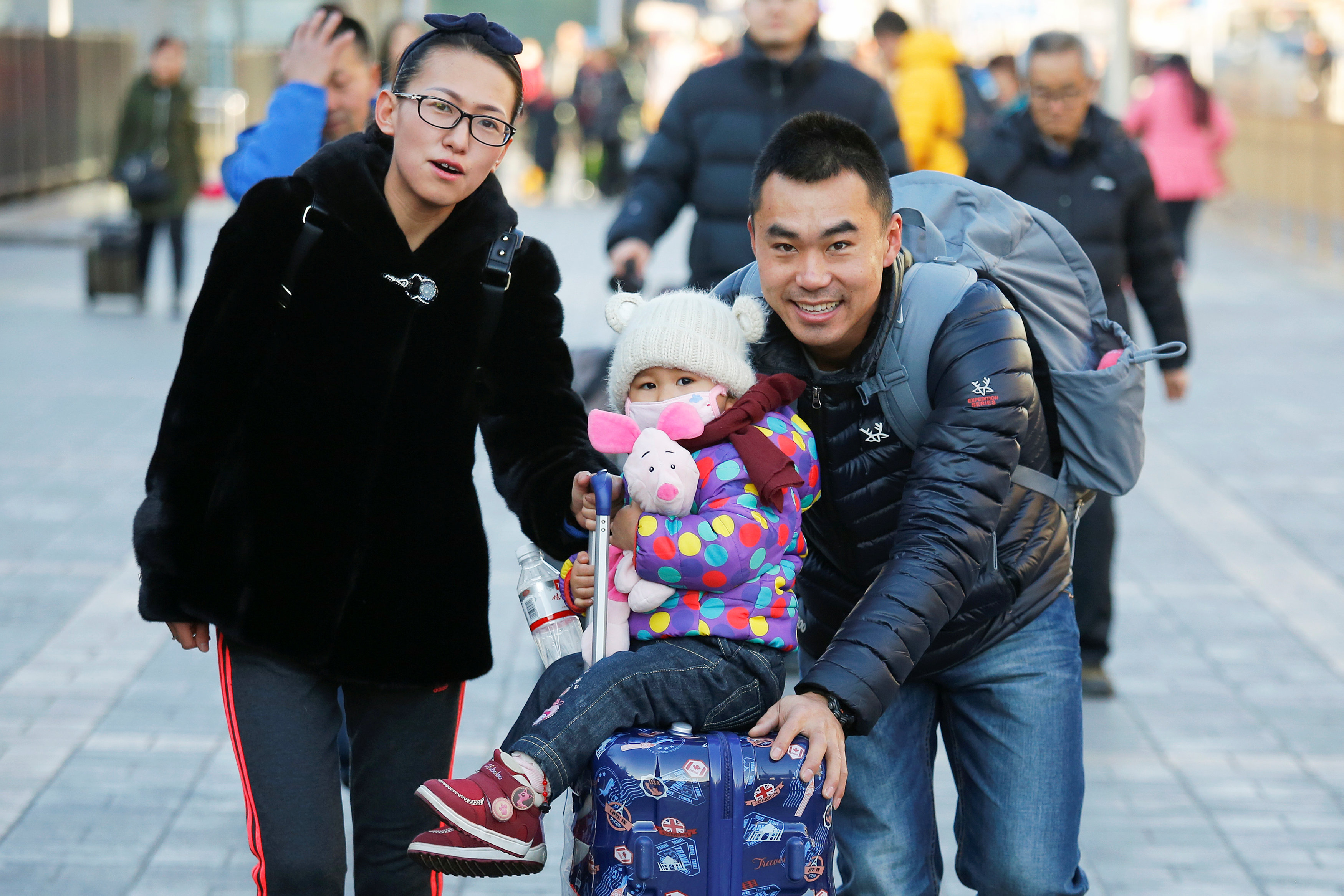 مواطنين برفقة ابنتهما فى شوارع بكين خلال احتفالات السنة الصينية الجديدة