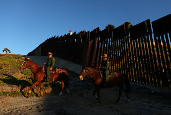 قوات من حرس الحدود الأمريكية تراقب انشاء السياج بين أمريكا والمكسيك