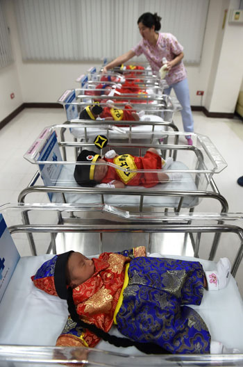 	ممرضة ترعى الأطفال فى المستشفى التايلاندية بعد ارتدائهم ملابس احتفالات السنة الصينية الجديدة