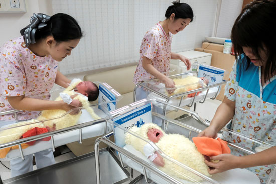 	ممرضات يلبسن الأطفال حديثى الولادة فى تايلاند ملابس احتفالات السنة الجديدة