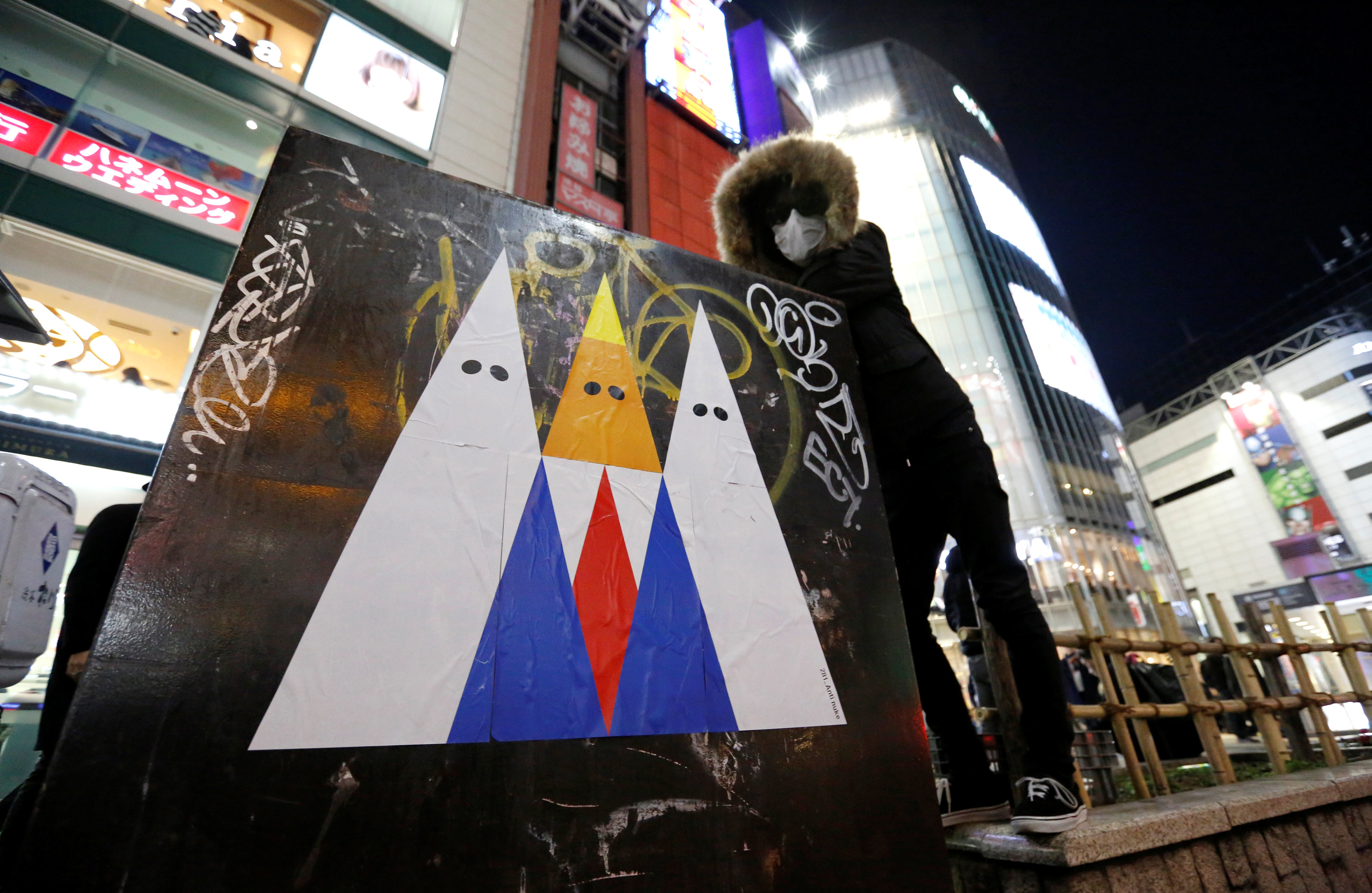 الفنان اليابانى 281 أنتينيوك بجوار الجرافيتى المنتقد لدونالد ترامب
