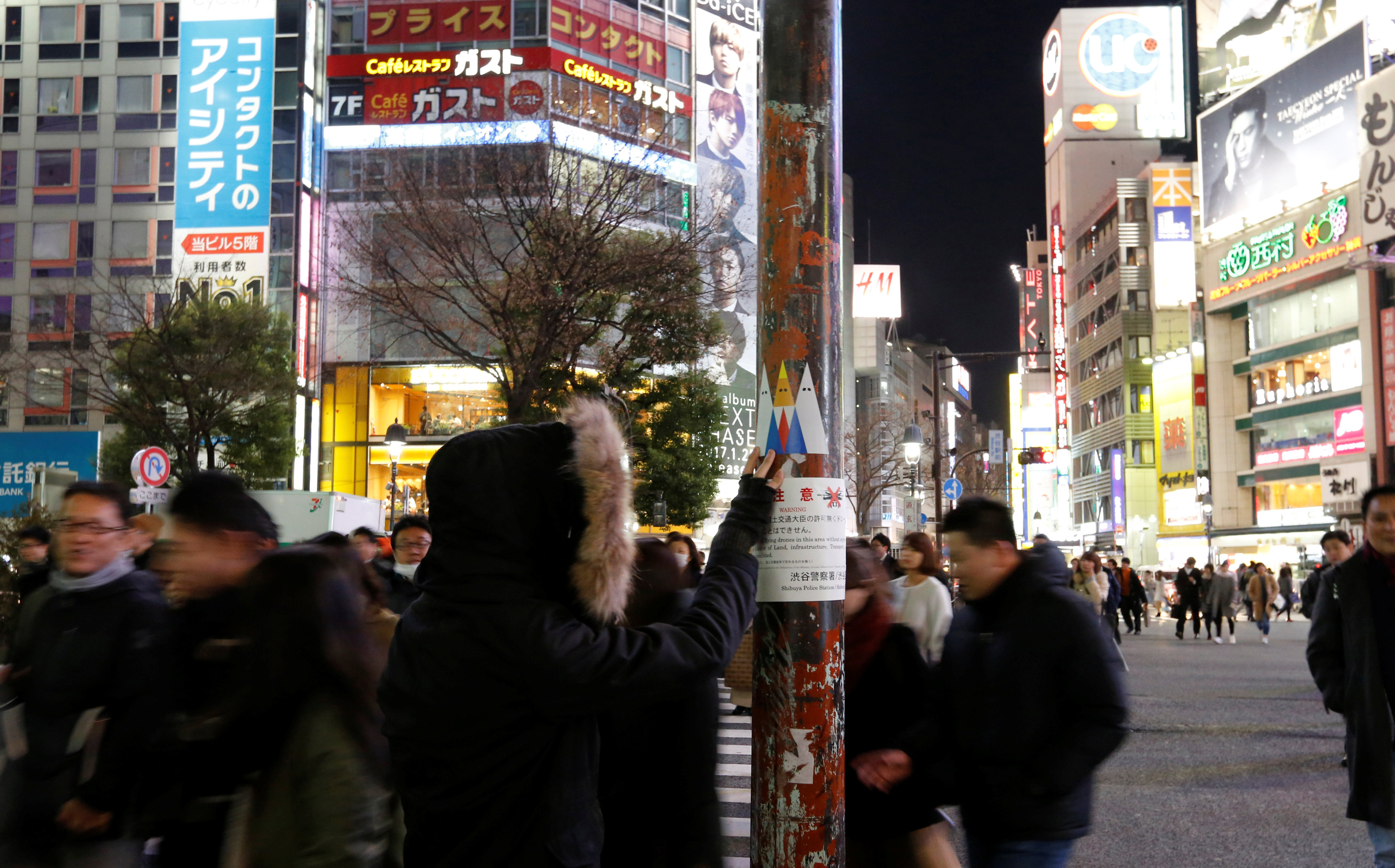المارة يقفون لمشاهدة جرافيتى يتنقد دونالد ترامب فى شوارع طوكيو