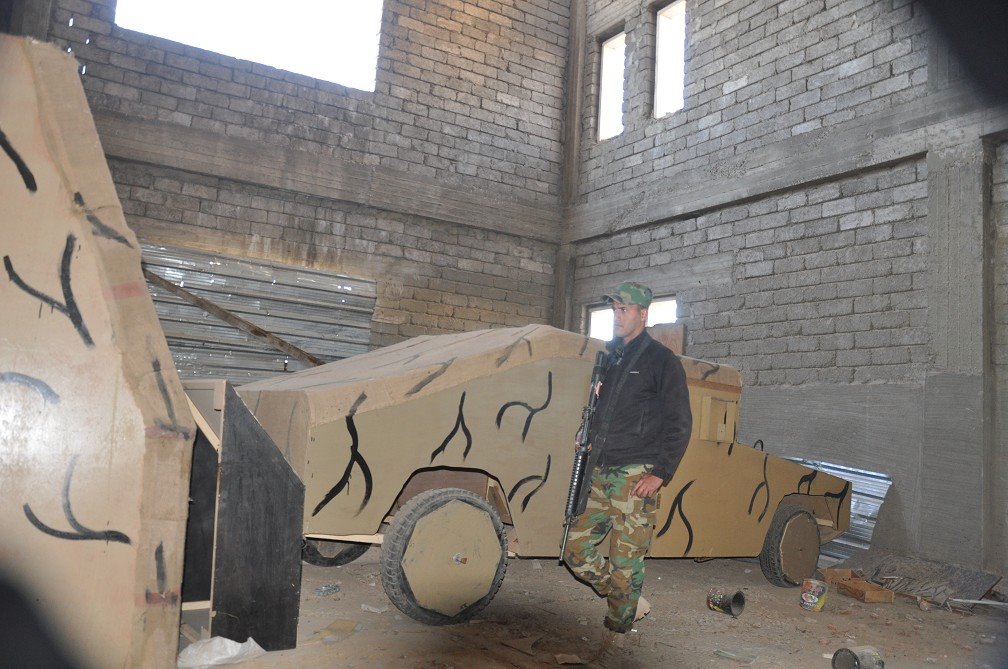 جندى عراقى بجانب سيارة خشبية استخدمها داعش لخداع الطائرات