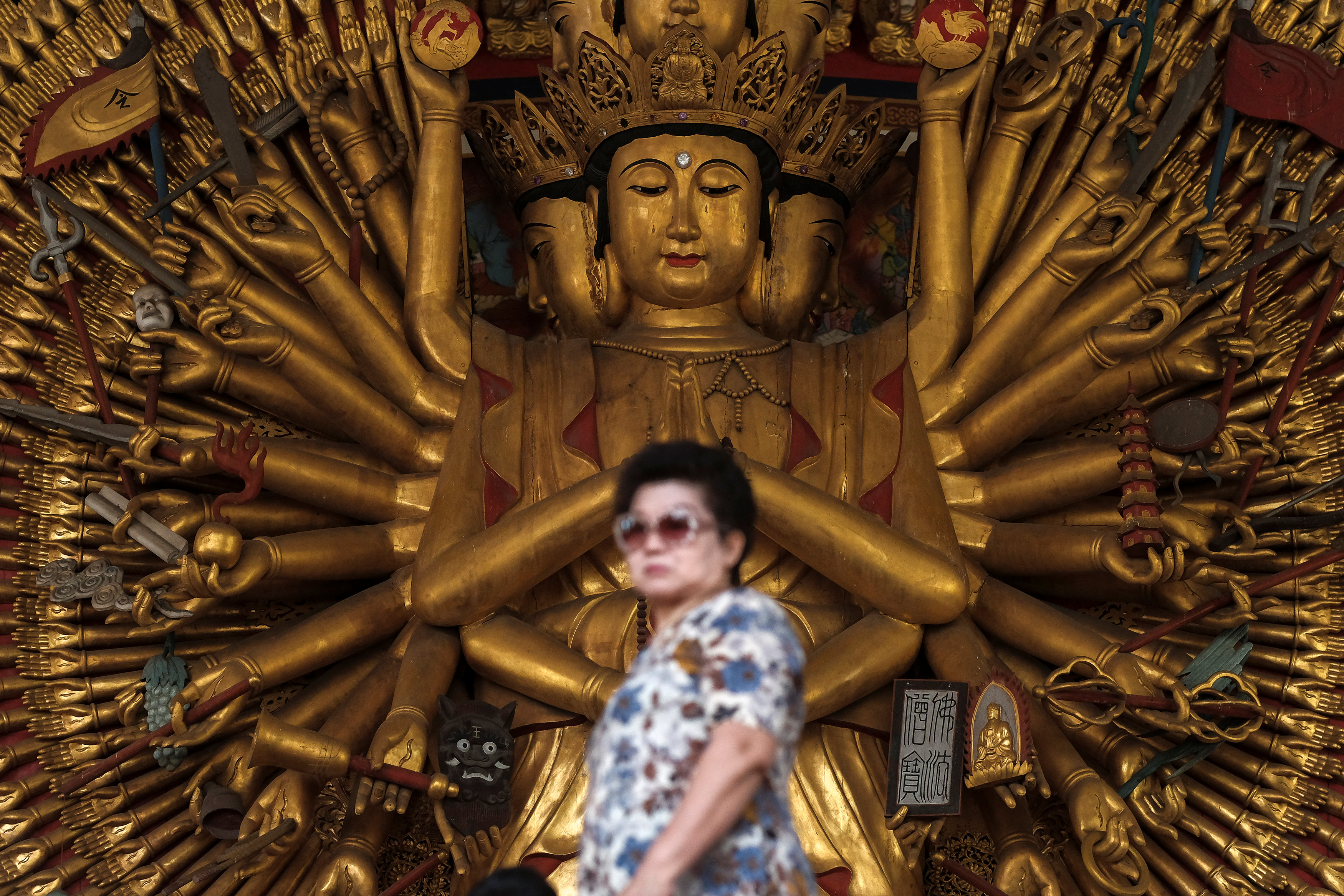 امرأة تقف أمام تمثال بوذي أفالوكيتسافارا أو غوان فى تايلاند