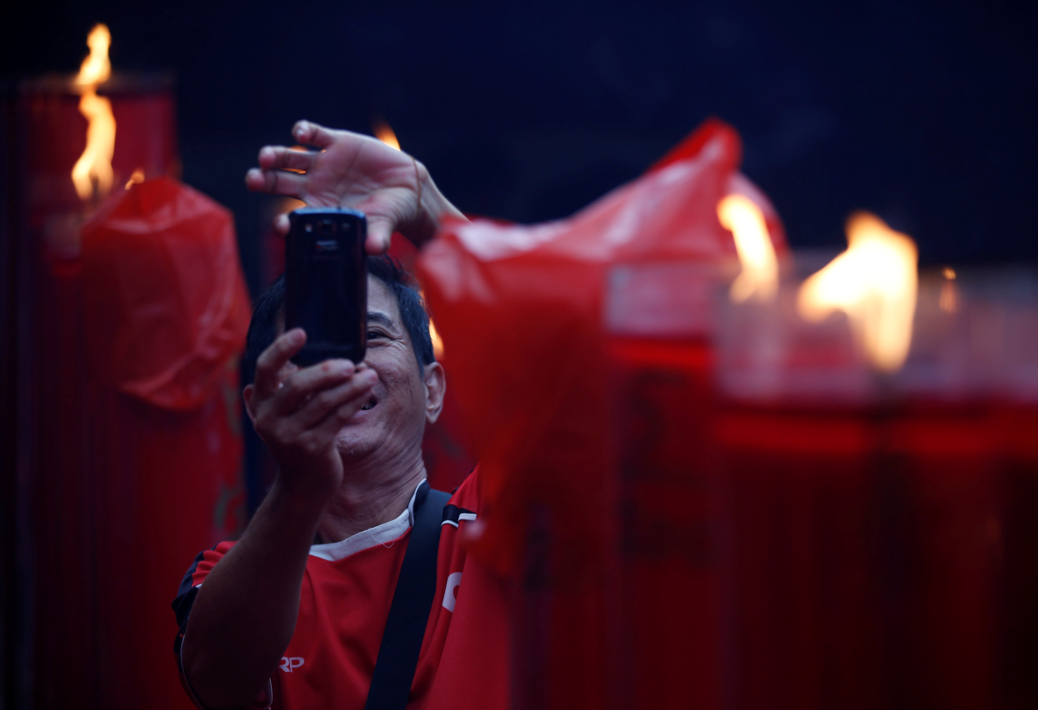 رجل يلتقط صورة خلال احتفالات السنة القمرية الجديدة فى معبد دارما بهاكتى بجاكرتا