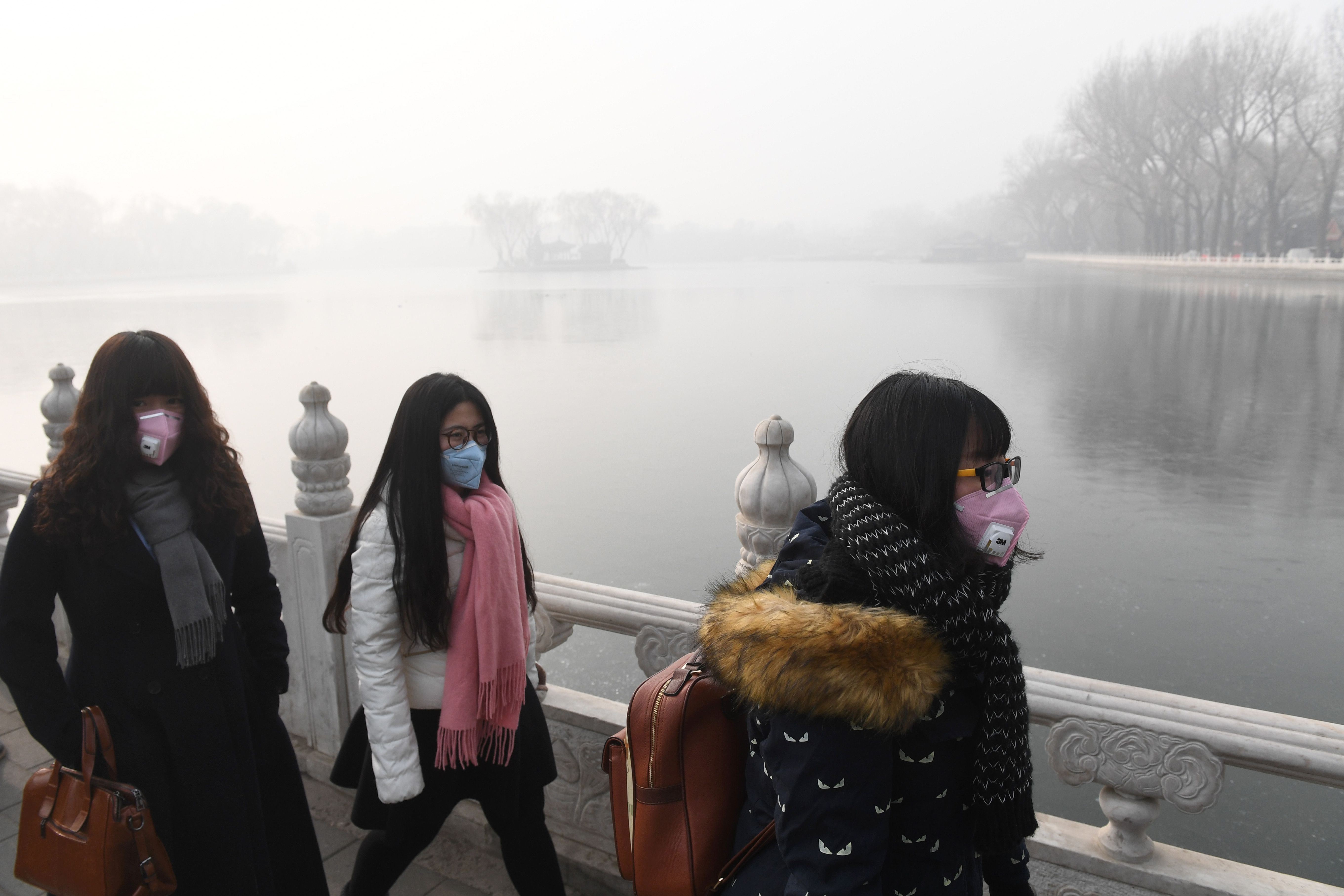 فتيات صينيات يسيرن على ضفة النهر