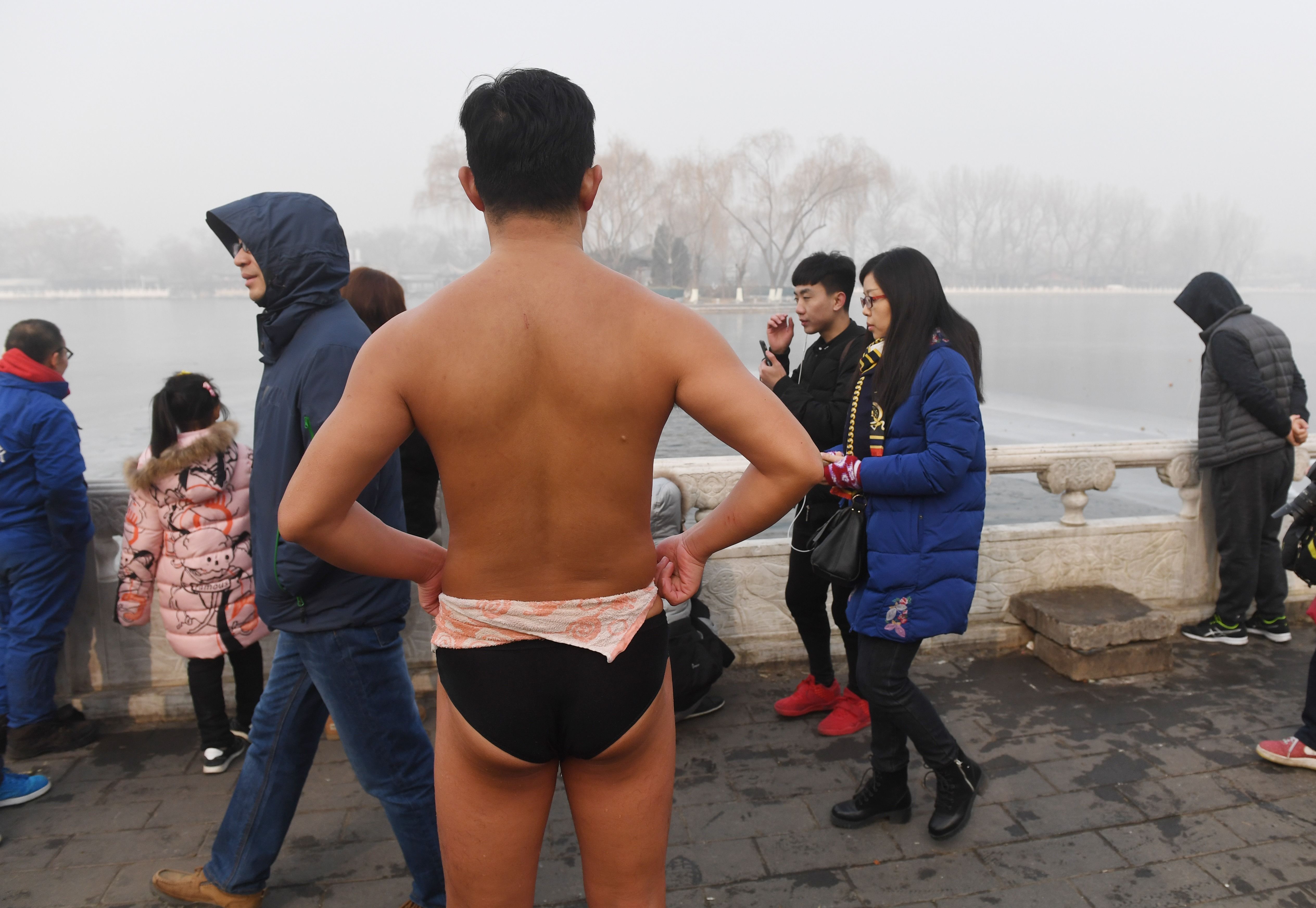 شاب صينى بملابس السباحة رغم برودة الجو
