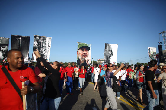 مواطنين يرفعون لافتات فيدل كاسترو أثناء الاحتفال بعيد الثورة الـ58