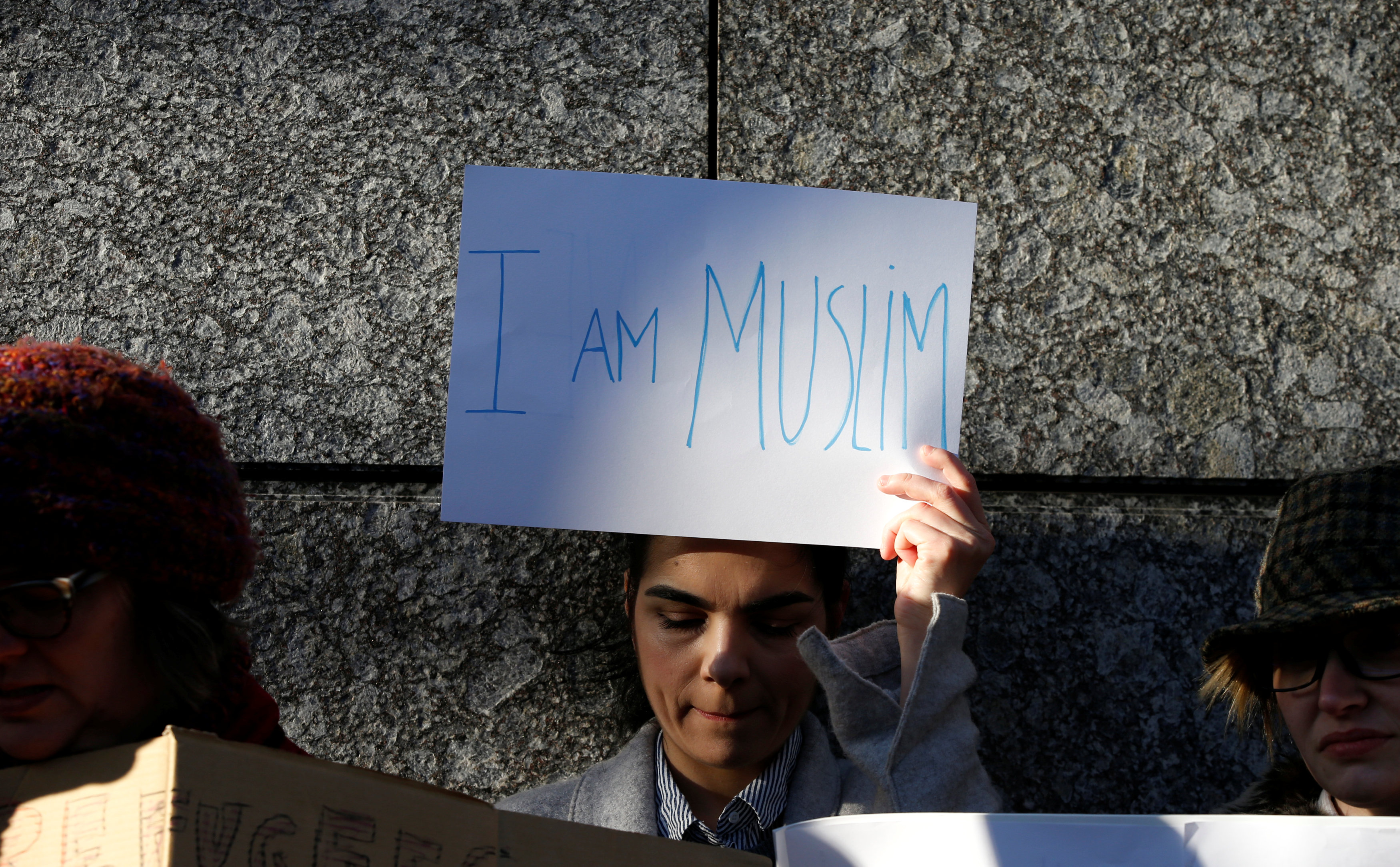 متظاهرة أمام السفارة الأمريكية فى طوكيو ترفع لافته مكتوب عليها أنا مسلمة