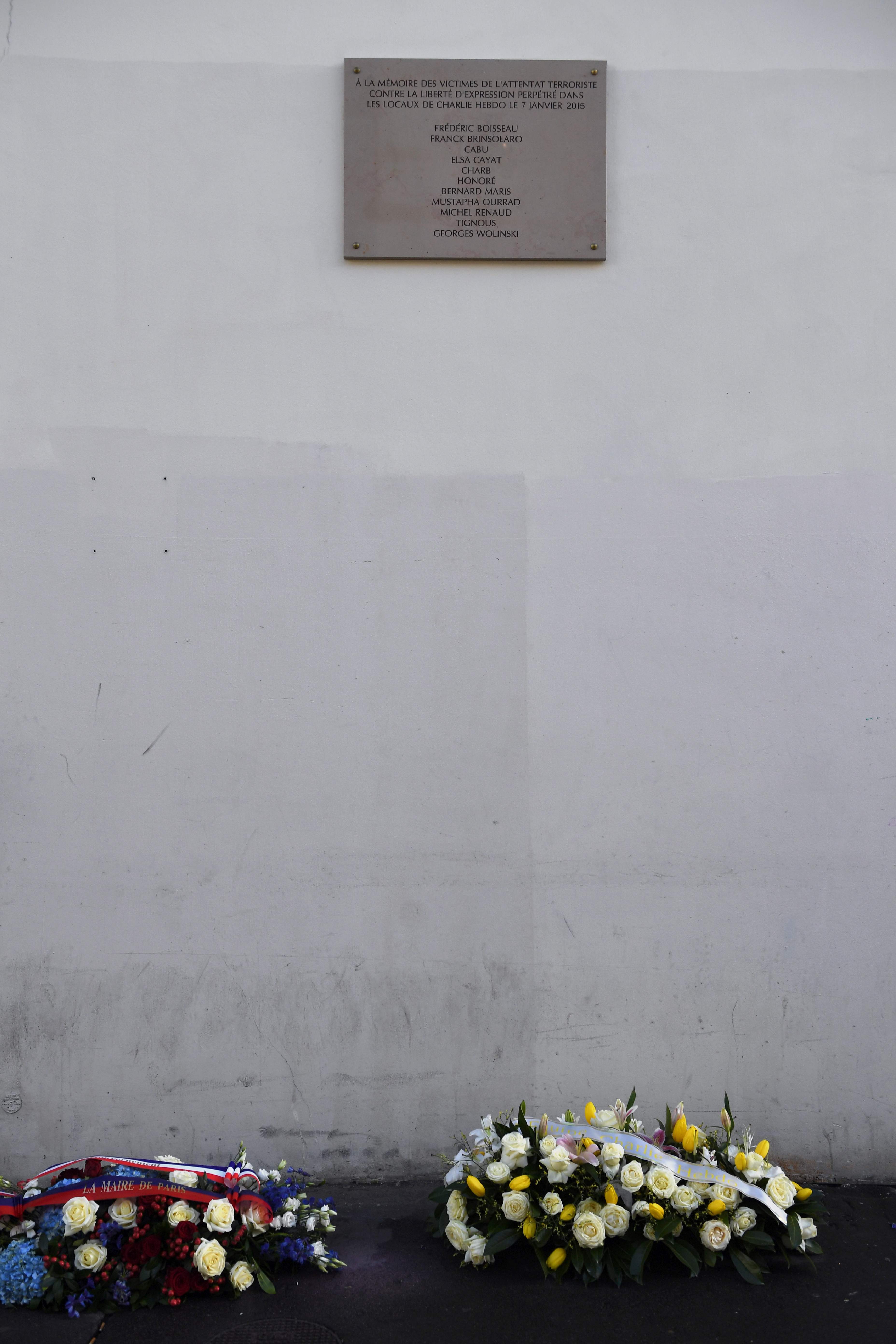 	الورود أمام لوحة تذكارية بأسماء الضحايا