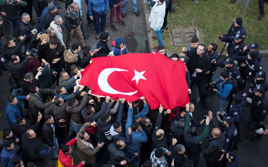 مواطنون أتراك يرفعون العلم التركى فى موقع الانفجار