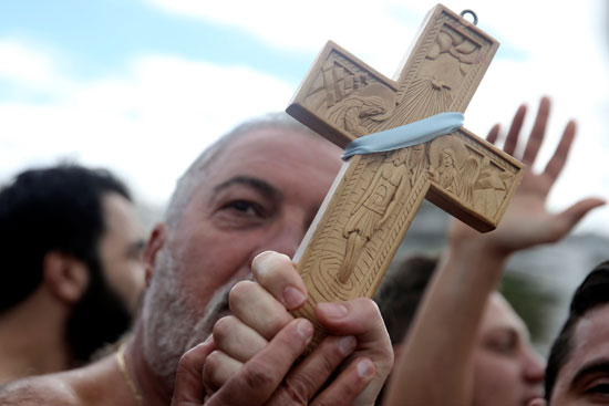 الصليب فى يد رجل يونانى خلال احتفالات عيد الغطاس
