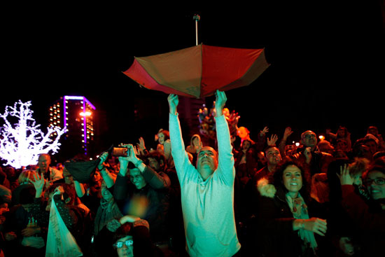 أحد المواطنين يستخدم مظلة لالتقاط الحلوى فى عيد الغطاس بأسبانيا