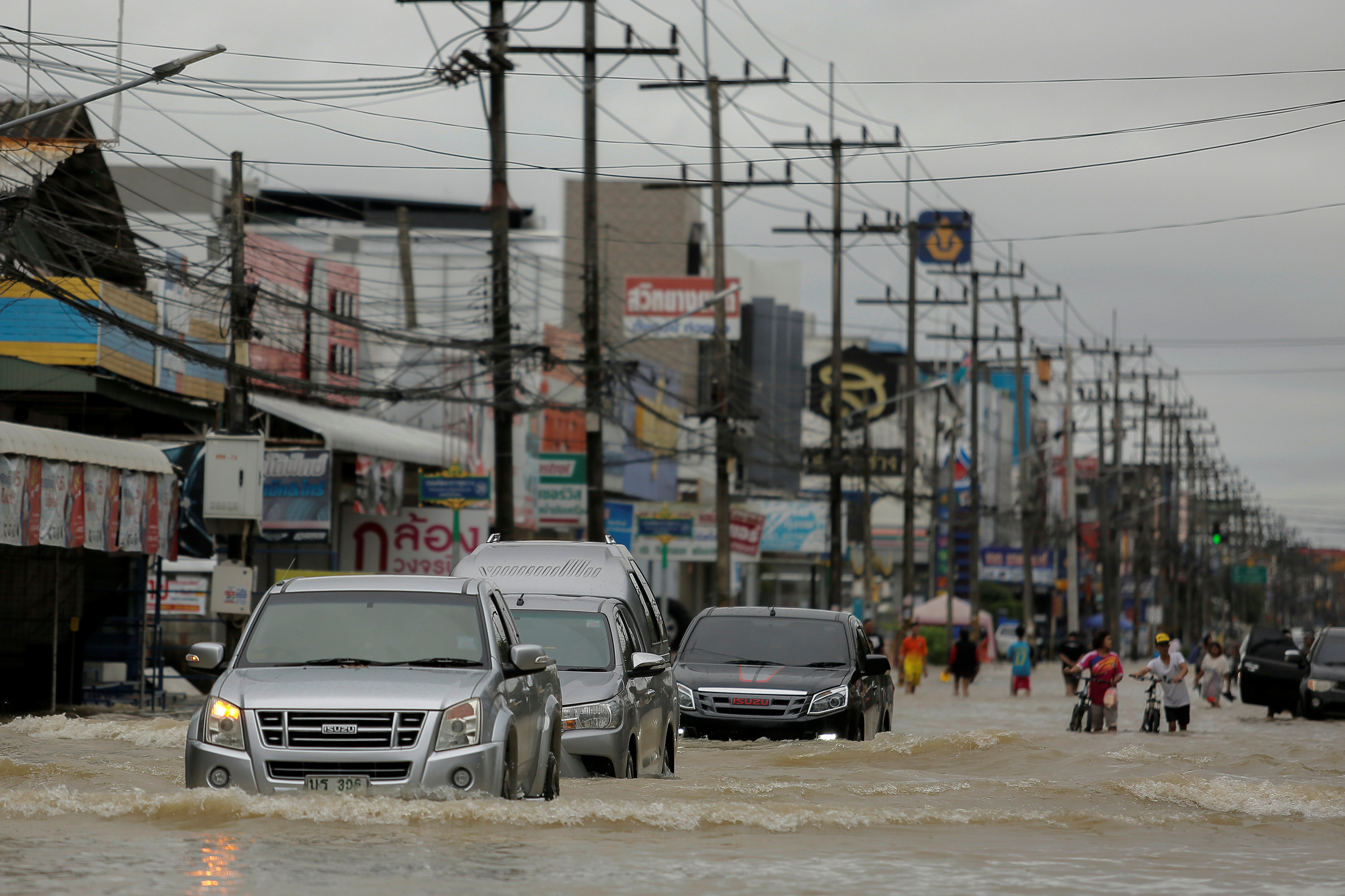 سيارات تسير فى مياه الفيضانات وسط شواع مقاطعة موانج - رويترز