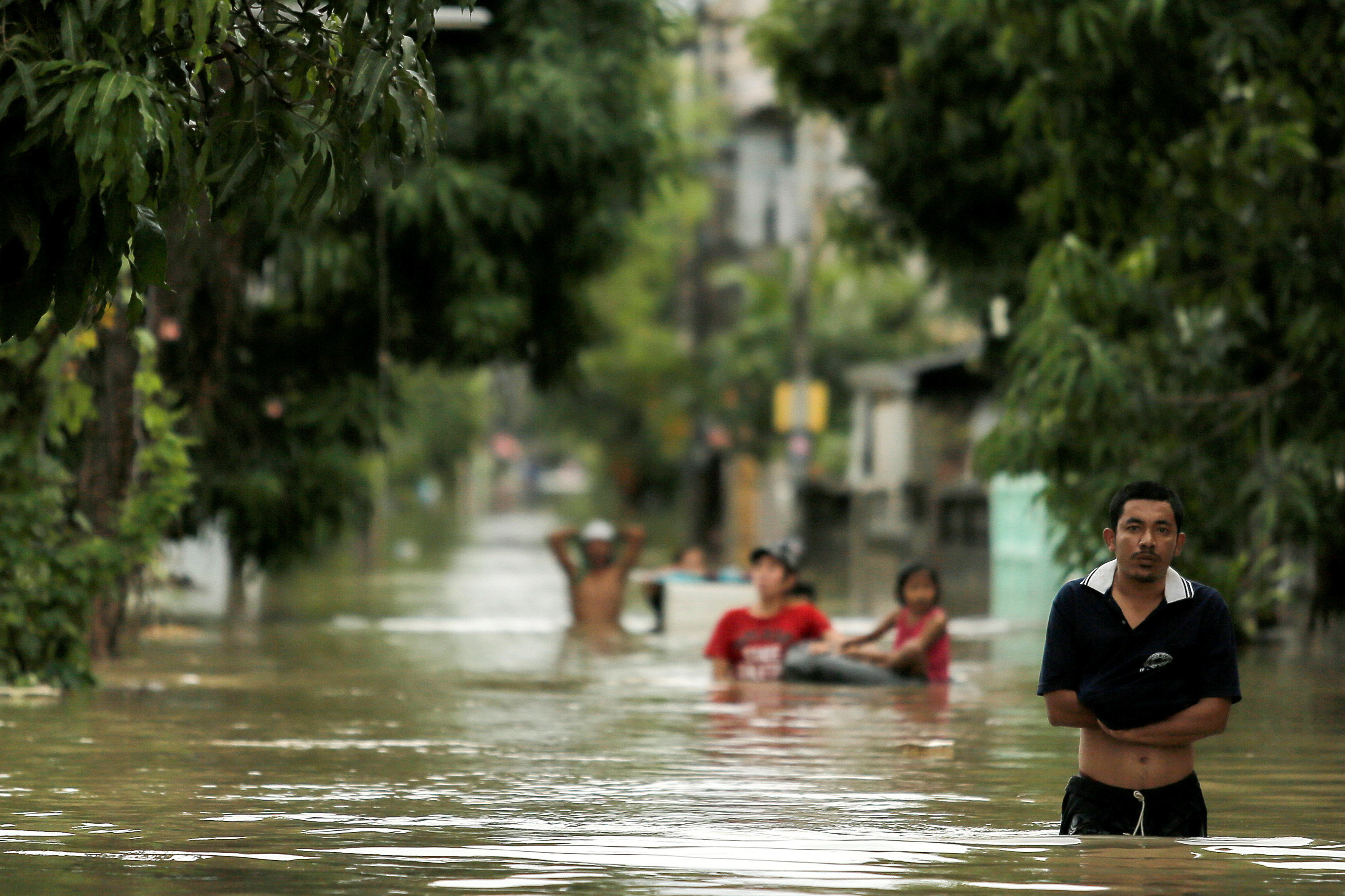 تايلانديون  يسيرون فى مياه الفيضانات
