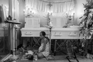 اليزابيث نافارو سيدة حامل تجلس بجانب نعش ابنها وزوجها يوم ١٤ ديسمبر الماضى