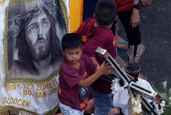 طفل يحمل نسخة مقلدة لتمثال الناصرى الأسود فى الفلبين