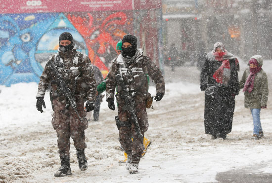 أفراد الشرطة التركية يتجولون فى الأسواق خلال تساقط الثلج