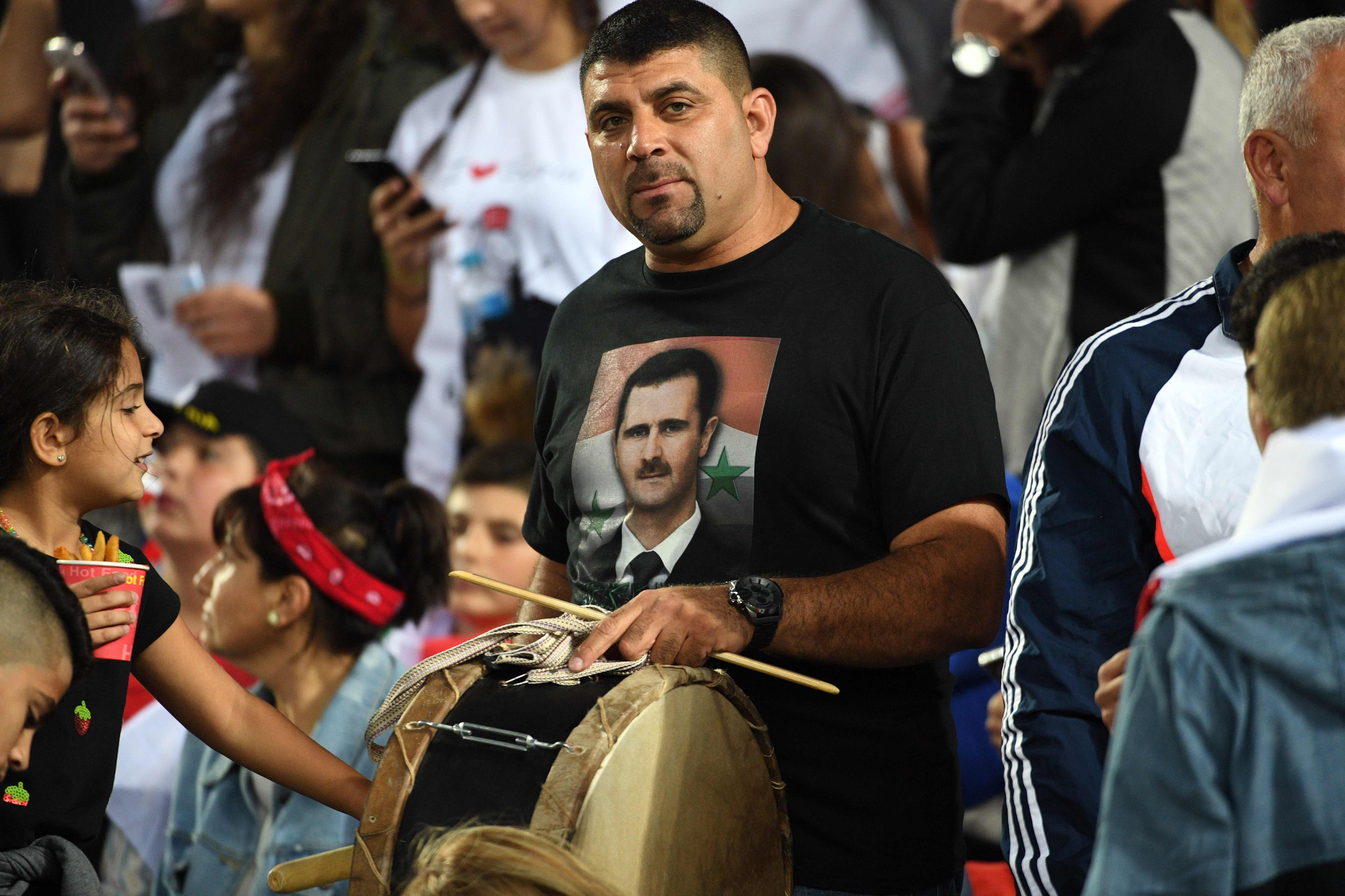 مشجع سورى يحمل صورة بشار الأسد