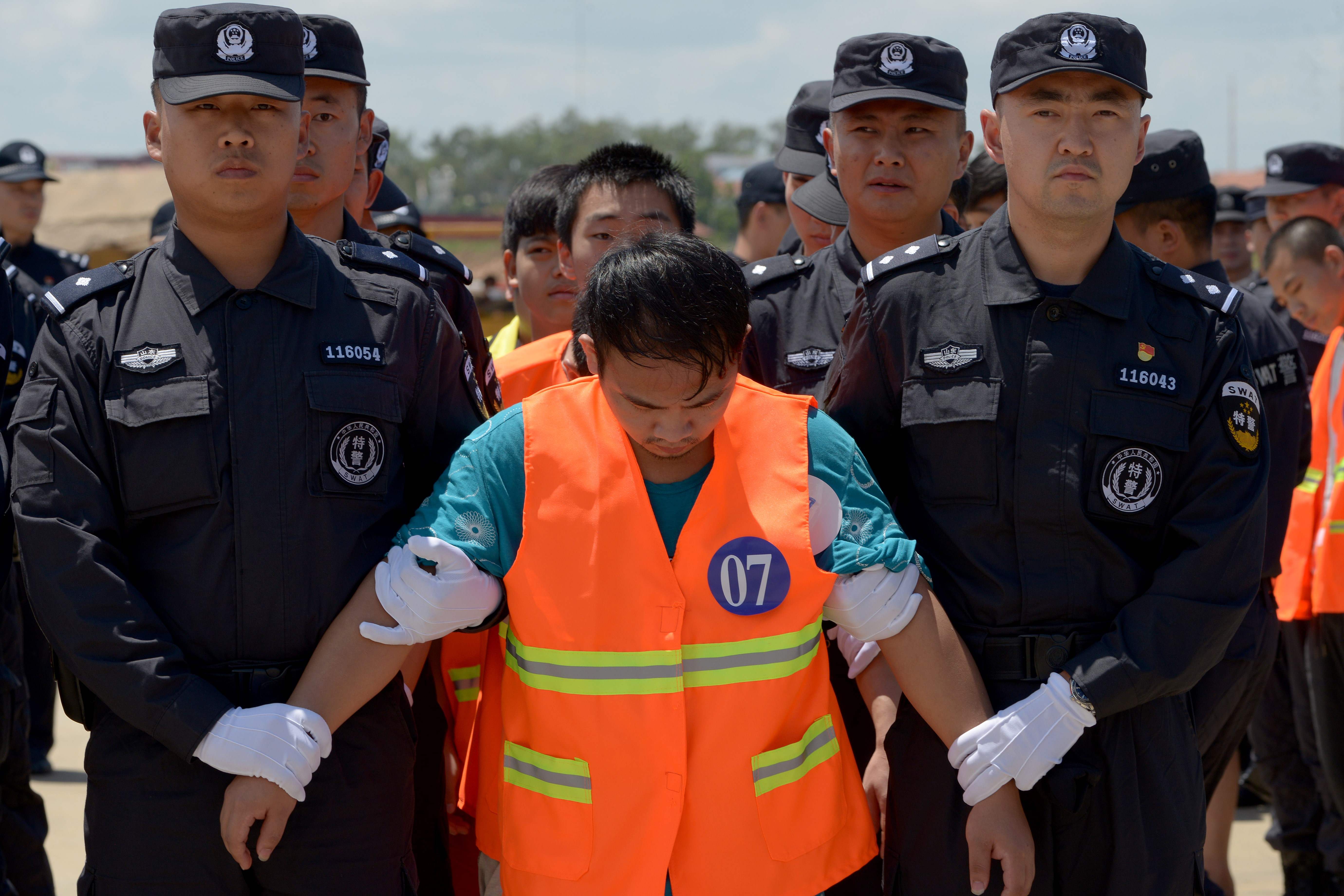 طابور للمتهمين الصينيين قبل نقلهم لمكان احتجازهم