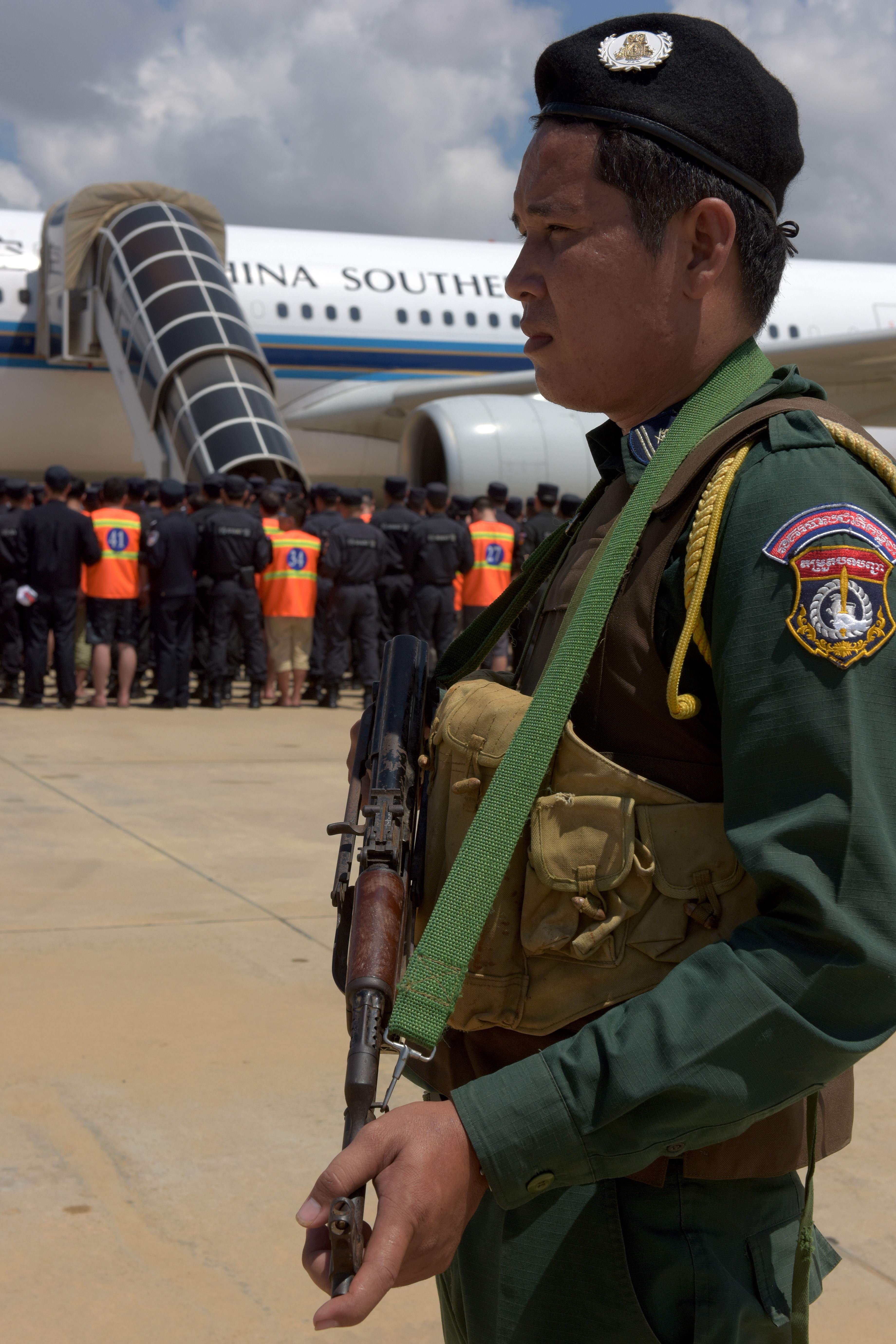 شرطى مسلح يؤمن تسلم المتهمين المرحلين من كمبوديا