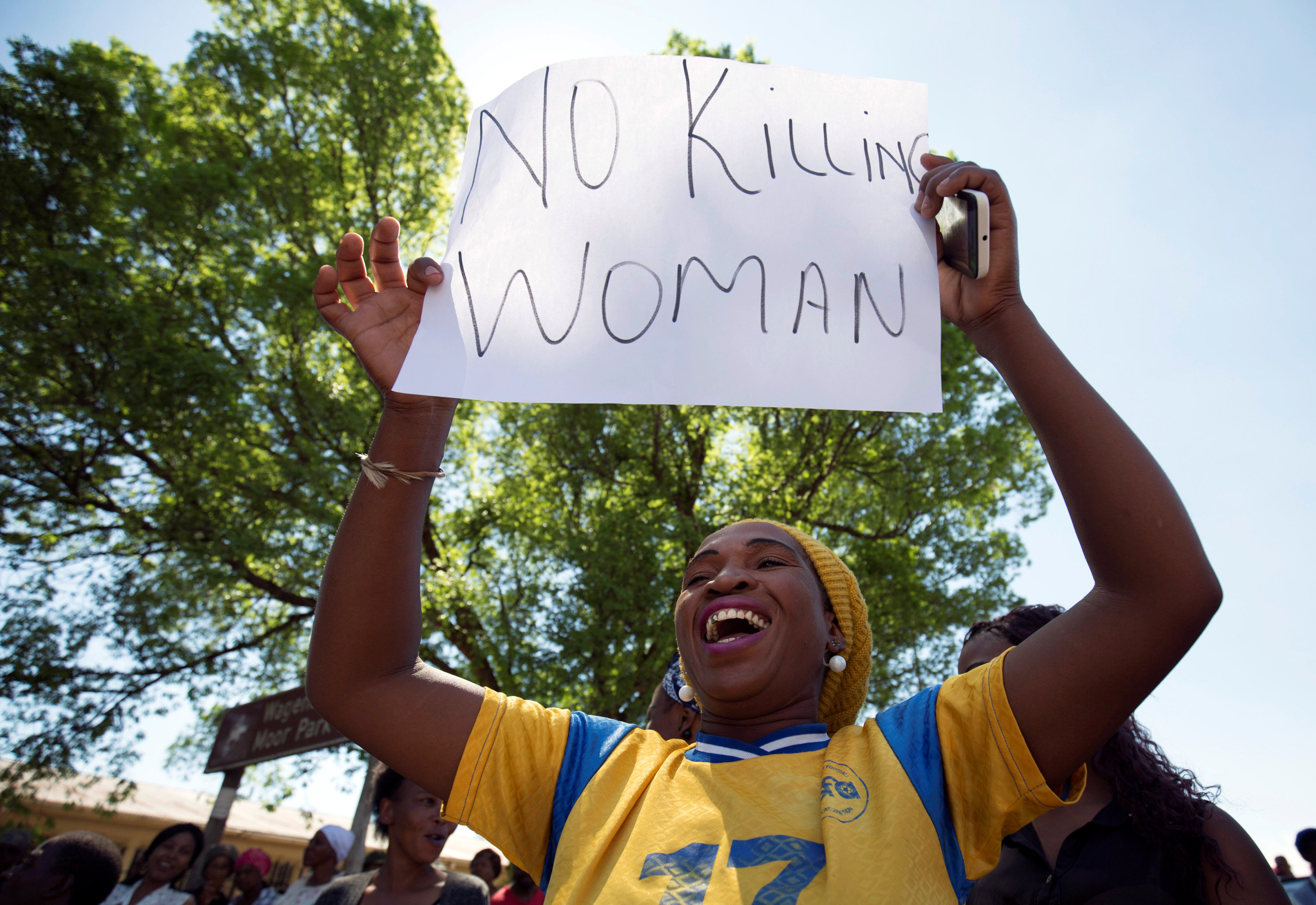 متظاهرة ترفع لافتة ضد قتل النساء فى جنوب أفريقيا