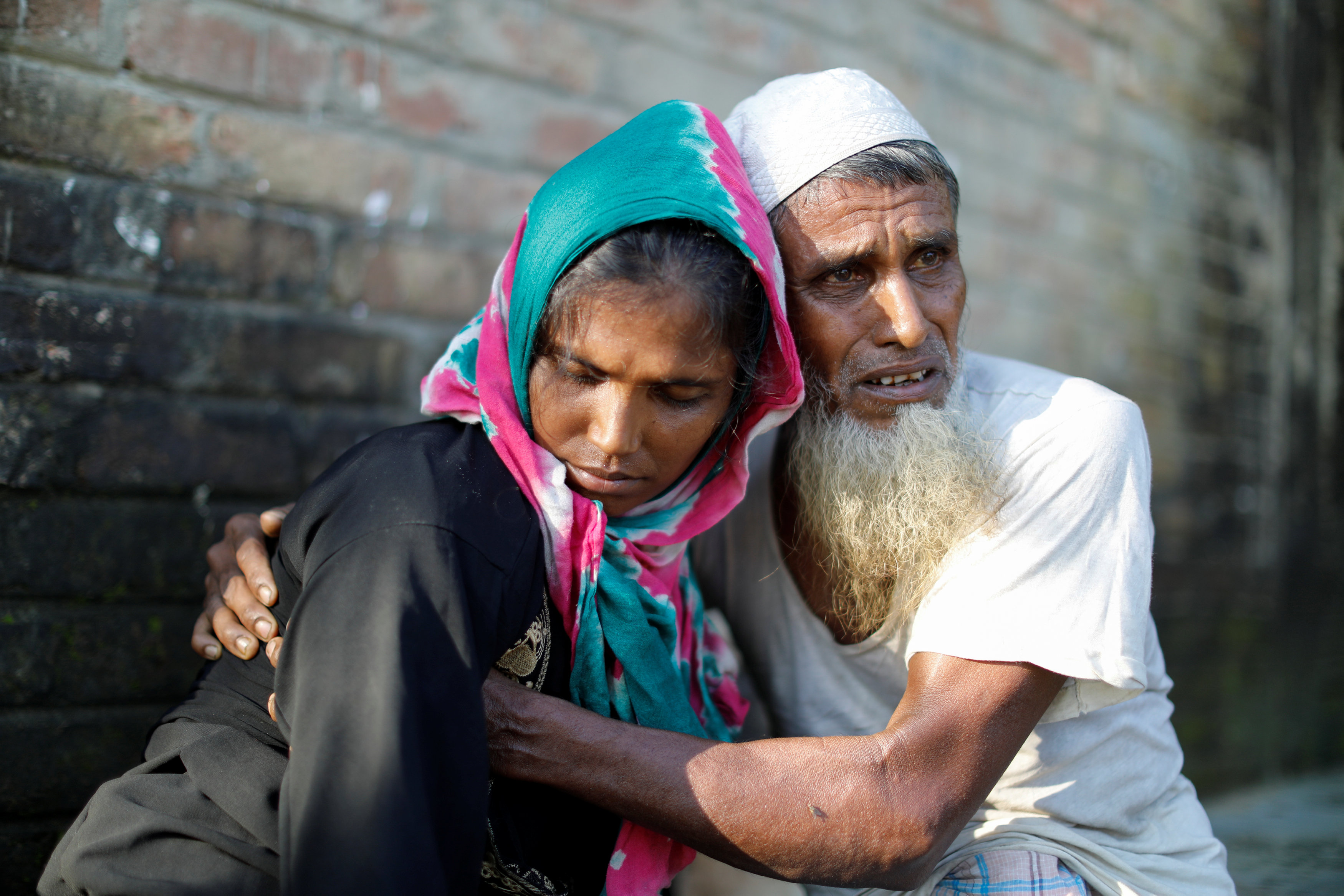 رجل بجواره ابنته عقب الهروب من ميانمار