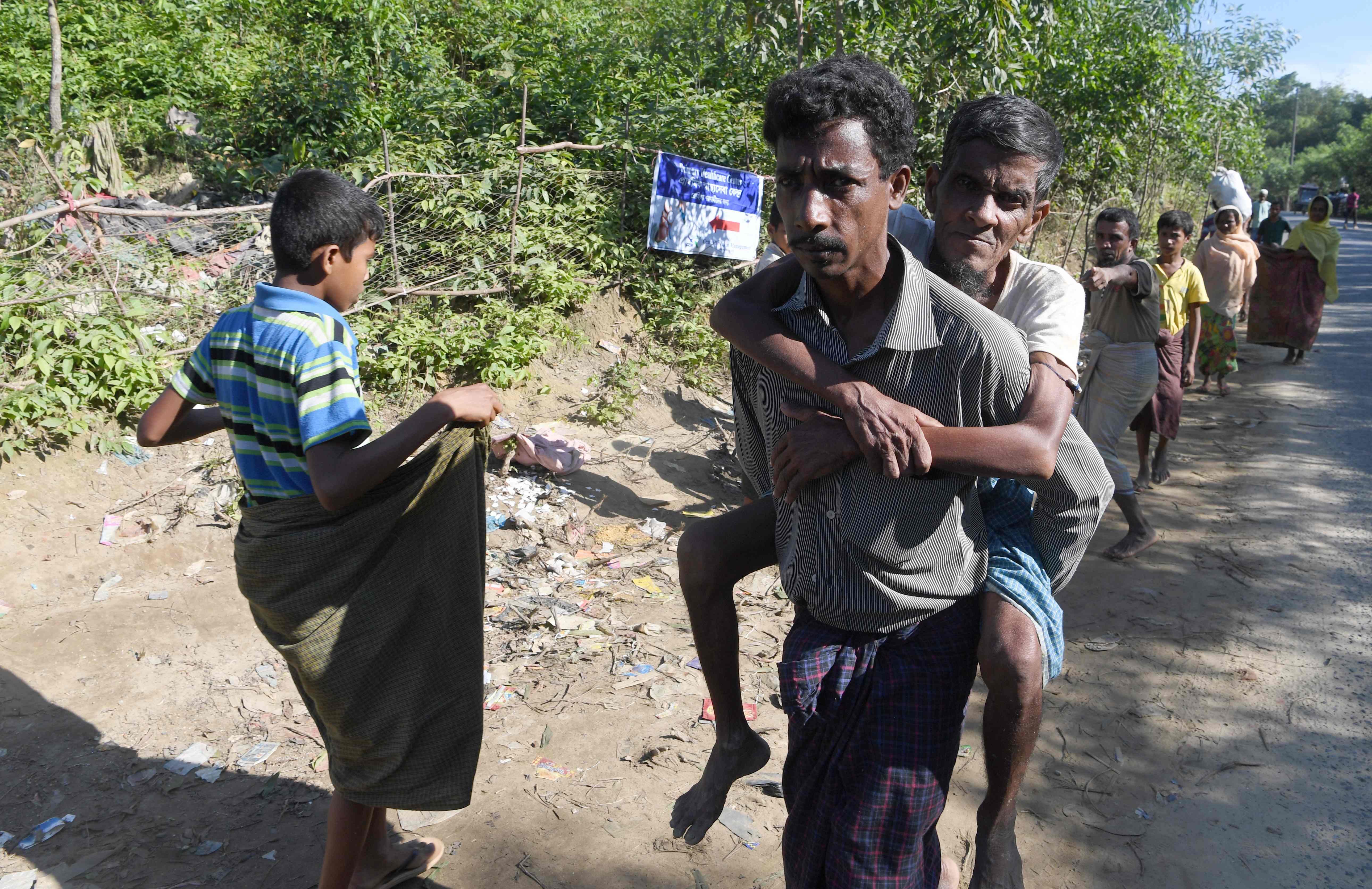 رجل يحمل والده على ظهره خلال الهروب من ميانمار