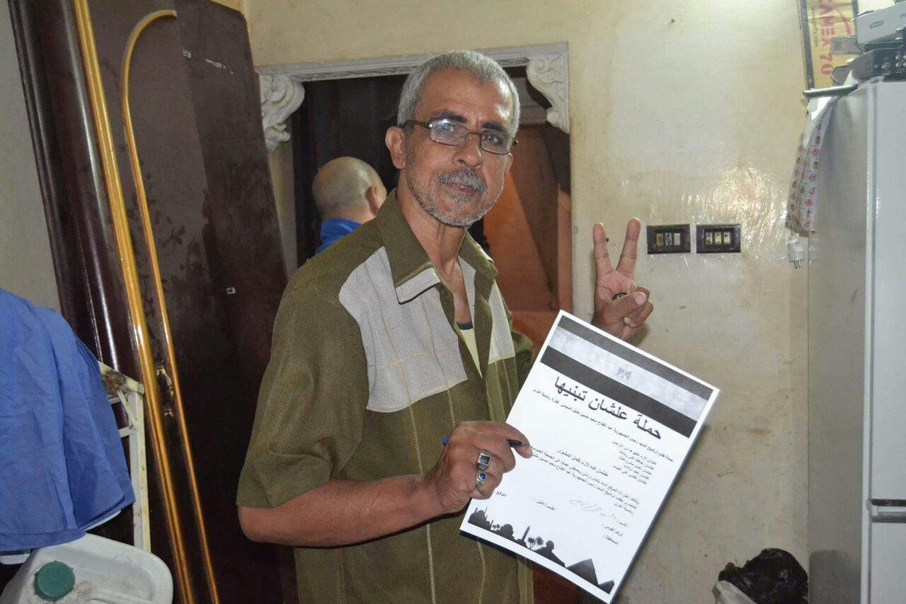 مواطن يرفع علامة النصر ويلتقط صورة مع الاستمارة