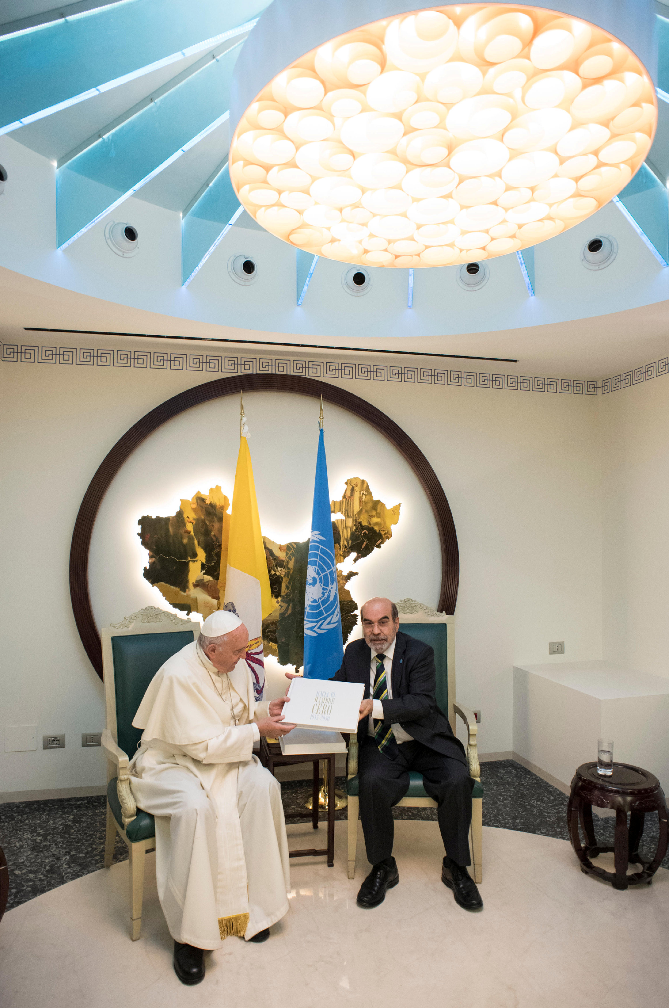 البابا فرانسيس يتحدث مع المدير العام لمنظمة الأغذية والزراعة جوزيه غرازيانو دا سيلفا خلال زيارته لمقر المنظمة في روما