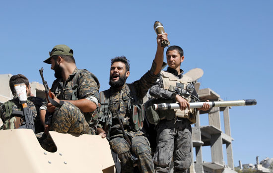 مقاتل سورى يحمل قذيفة فى يده أثناء احتفالات تحرير الرقة