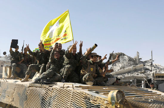 مقاتلو سوريا الديمقراطية يرفعون علامة النصر فى مدينة الرقة
