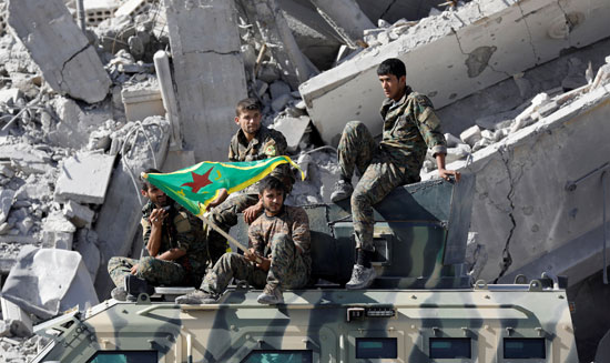 مقاتلو سوريا الديمقراطية يحملون أعلامهم الخاصة