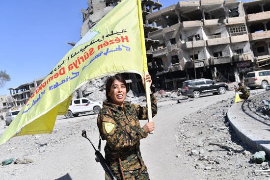 مقاتلة سورية ترفع علم قوات سوريا الديمقراطية فى الرقة