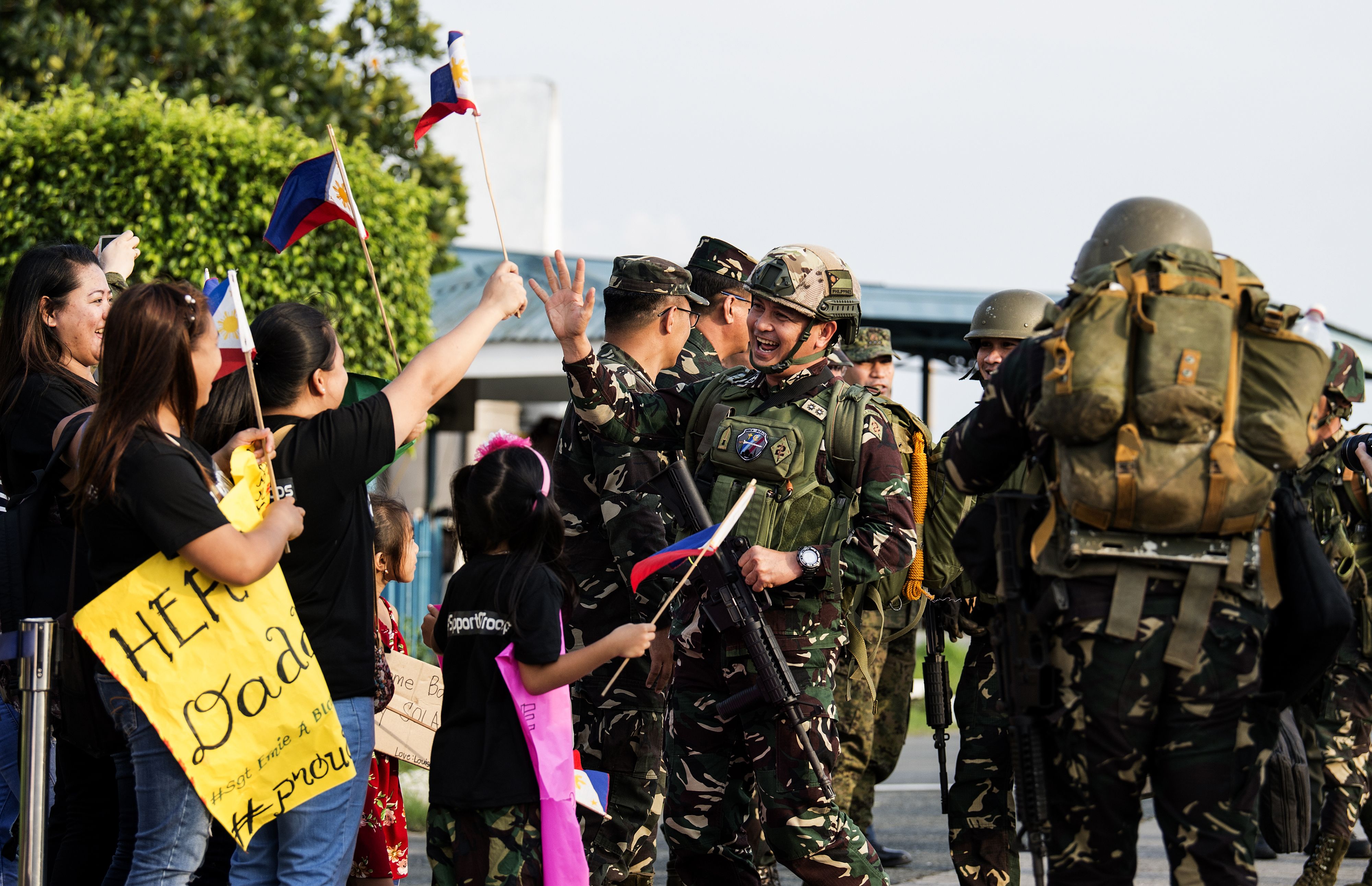 أسر الجنود الفلبينيين فى استقبالهم عقب نهاية القتال مع داعش