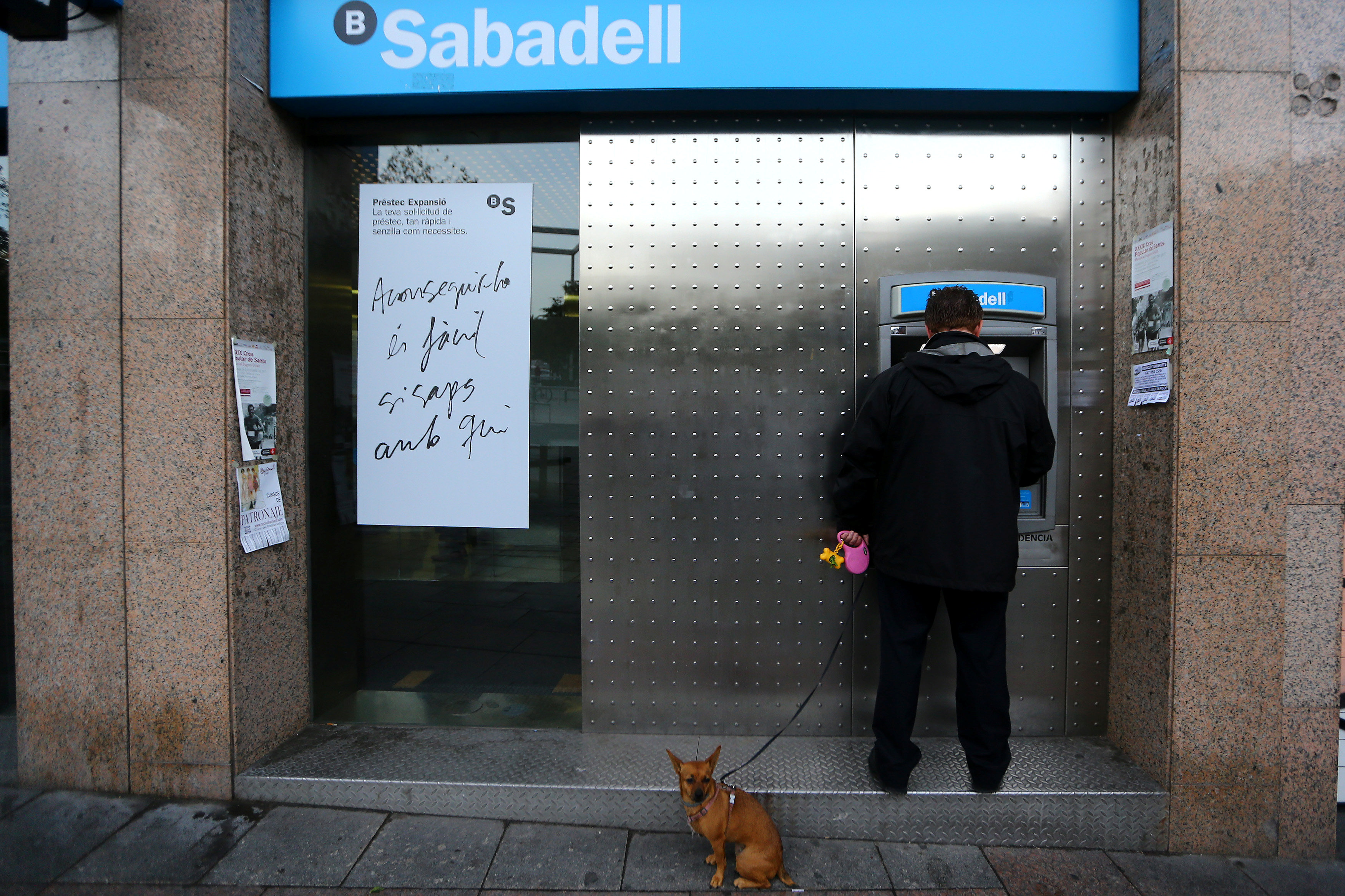 رجل يسحب أموالًا من البنك ضمن حملة فى كتالونيا اعتراضا على عقوبات اسبانيا