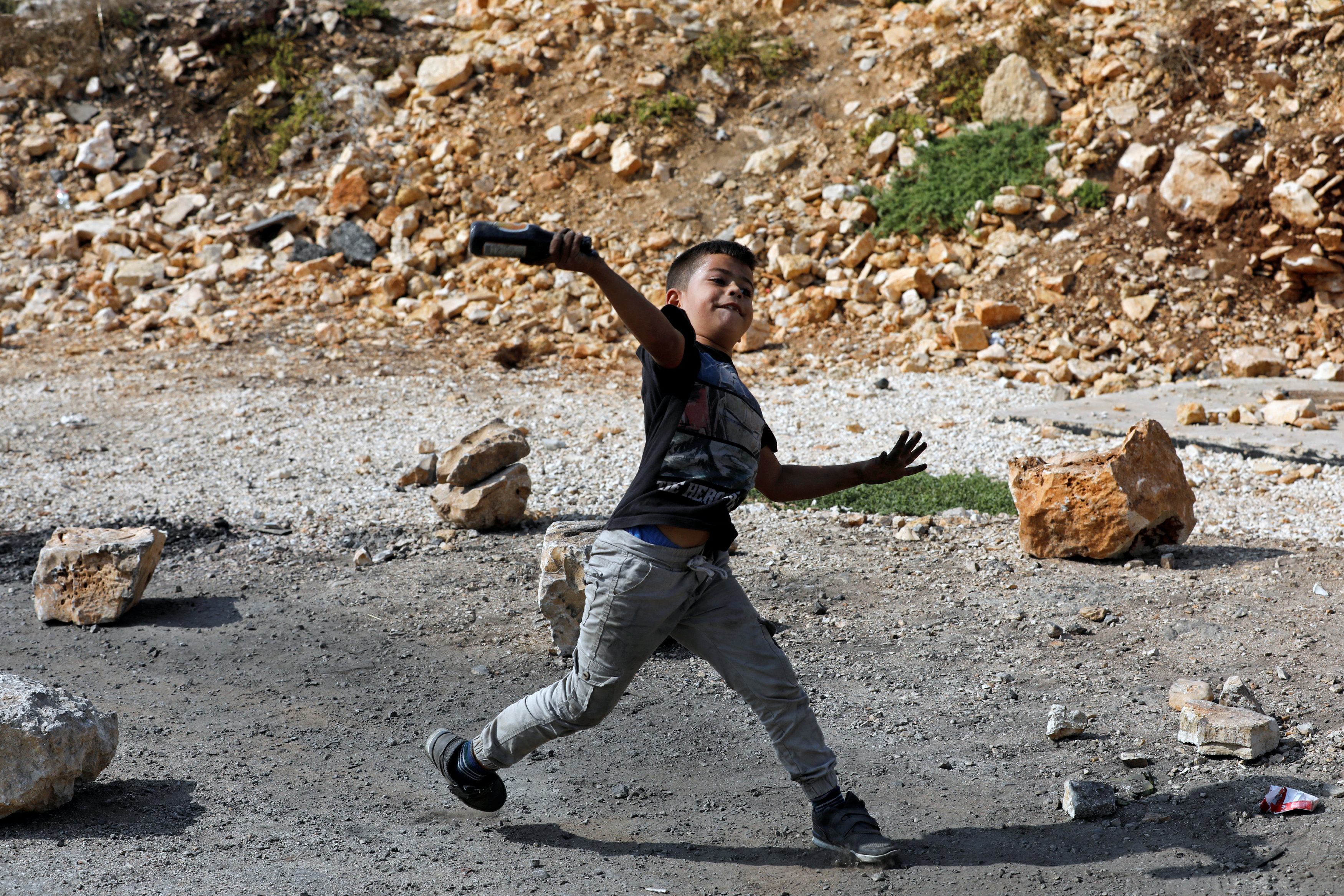 طفل فلسطينى يواجه رصاص قوات الاحتلال بالحجارة