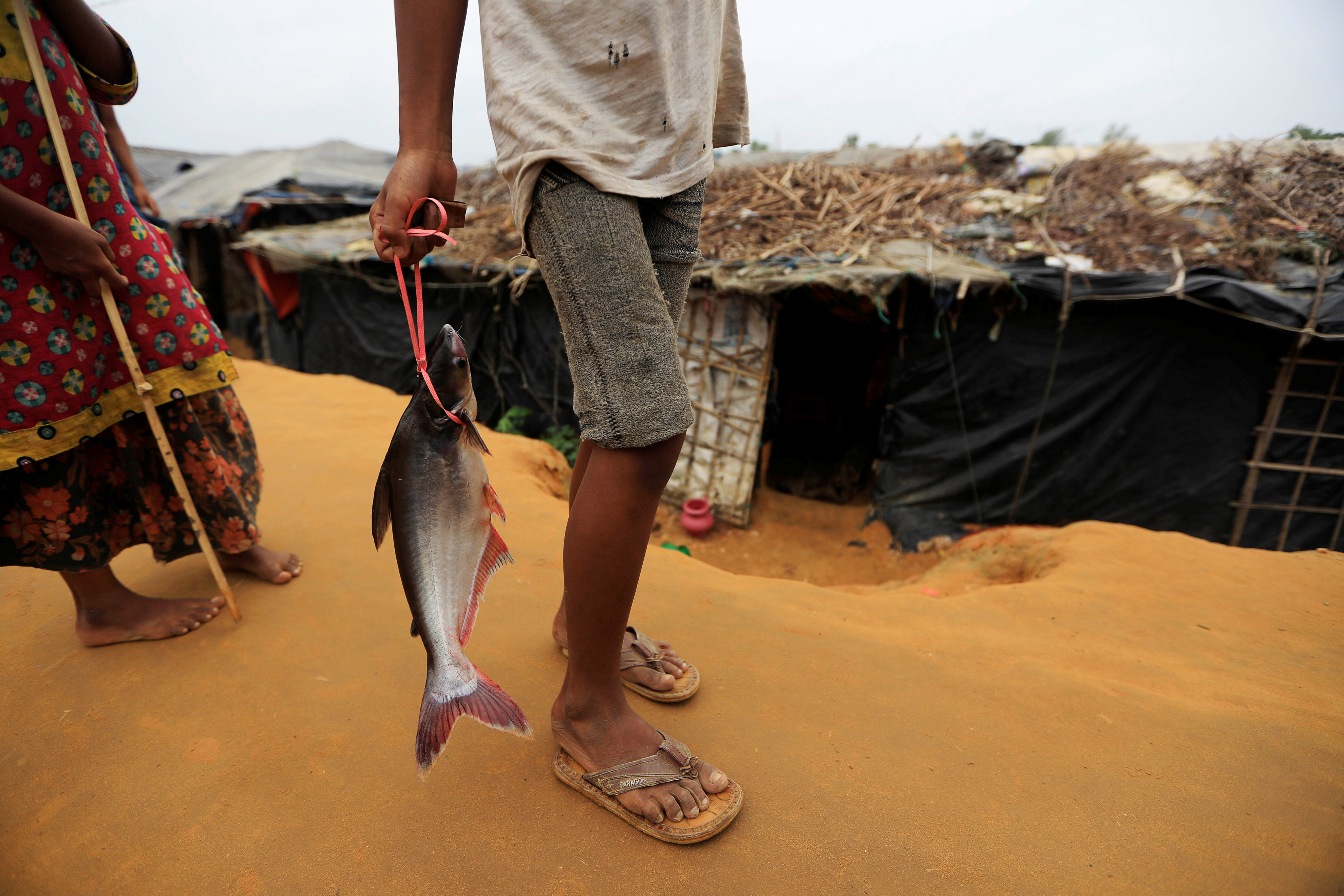 لاجئ من الروهينجا يحمل سمكة