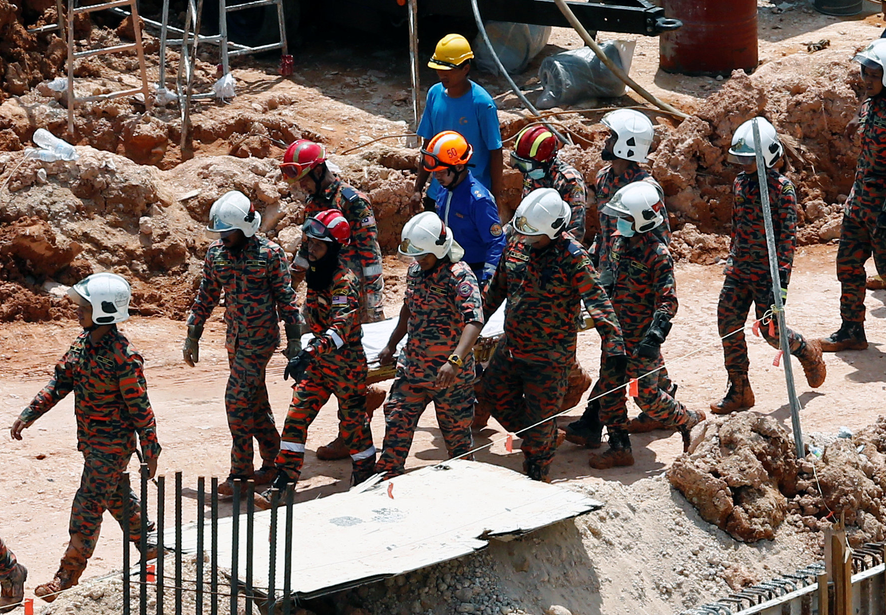 فرق الإنقاذ تنقل جثمان أحد ضحايا الانهيار الأرضى فى ماليزيا