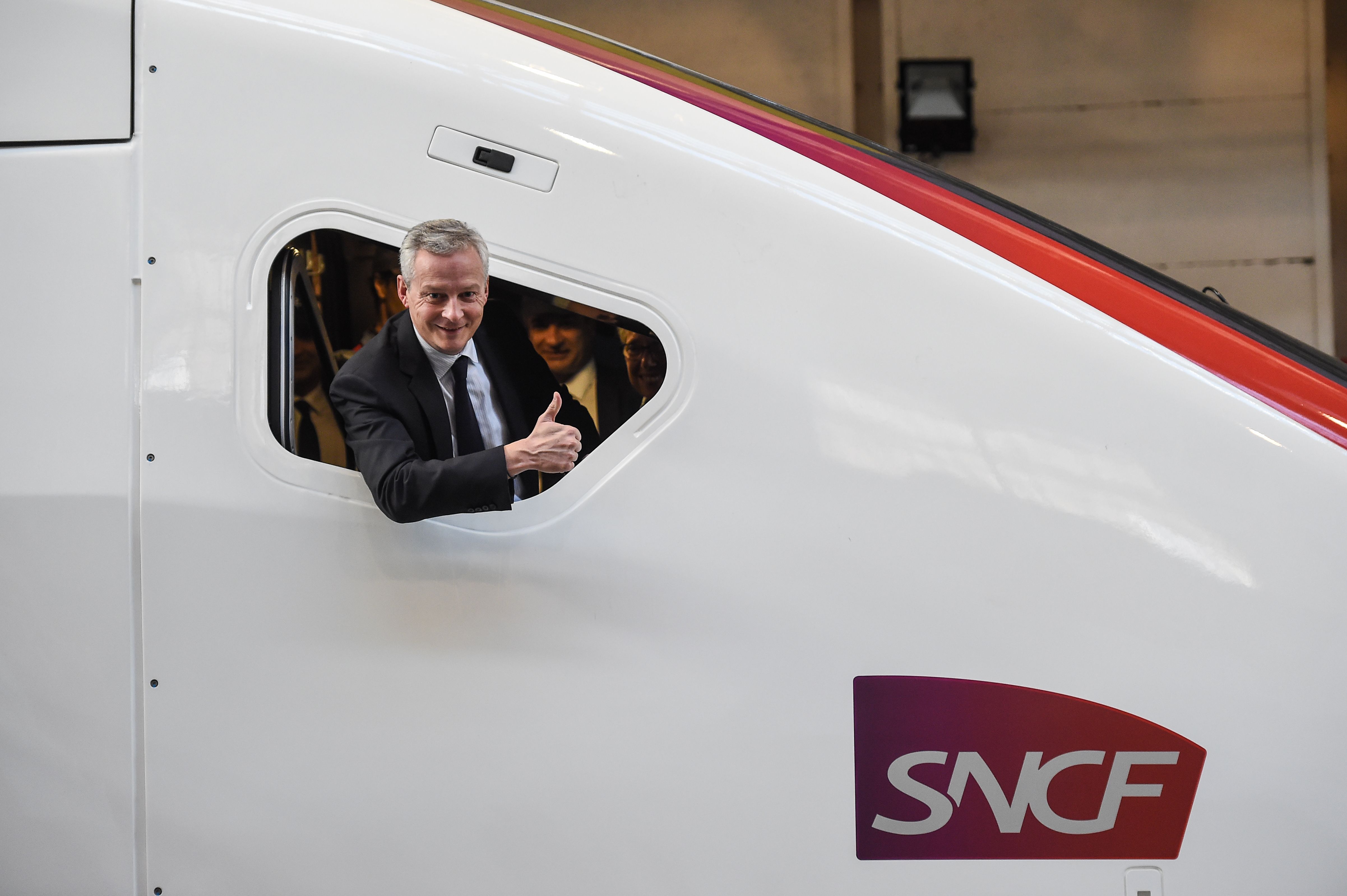 وزير الاقتصاد الفرنسي برونو لو مير يشير من نافذة القطار