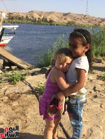 طفلة إنجليزية فى وصلة أحضان ولهو مع طفلة مصرية على ضفاف النيل بالأقصر