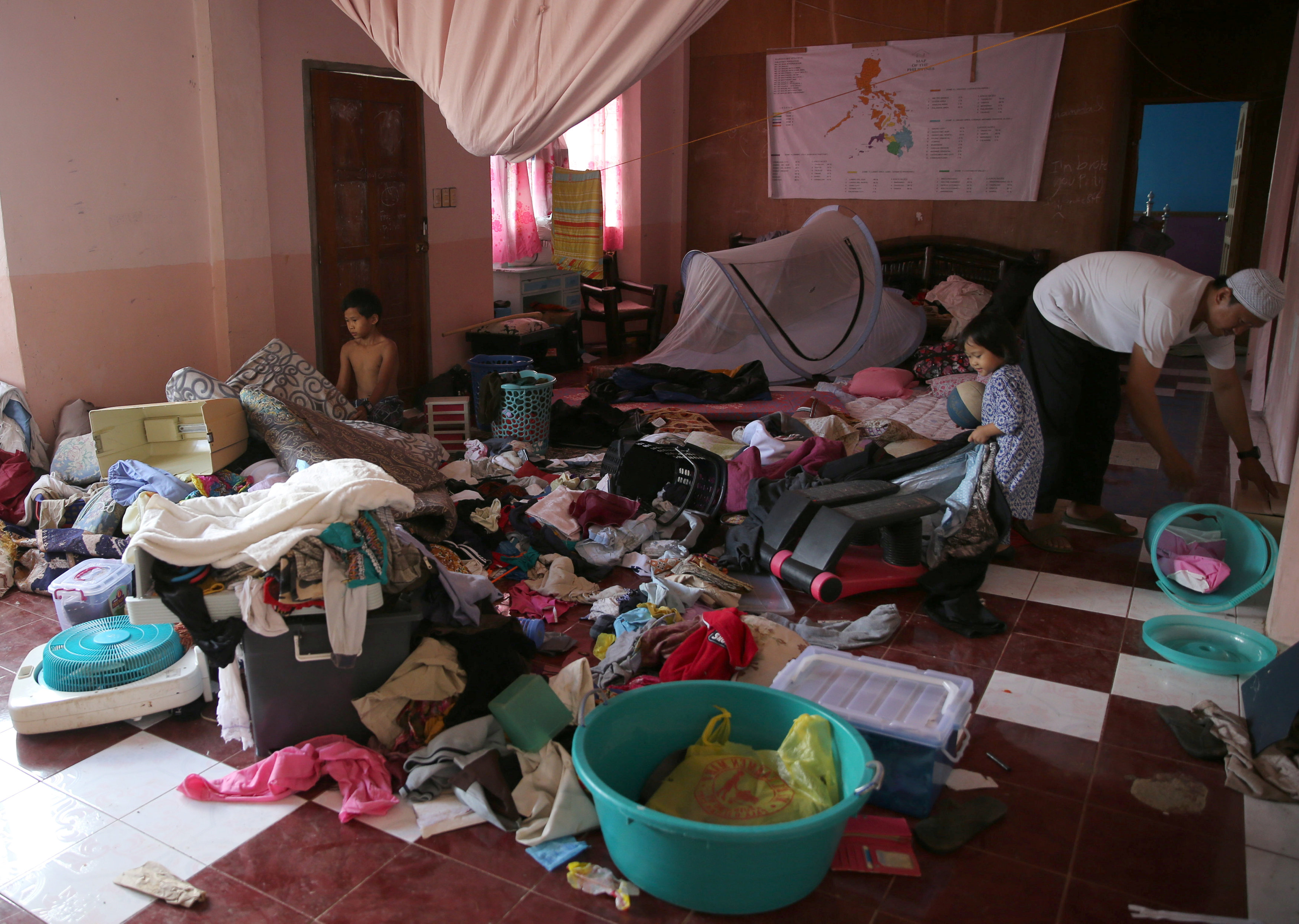 أسرة فلبينية تنظف منزلها بعد طرد تنظيم داعش