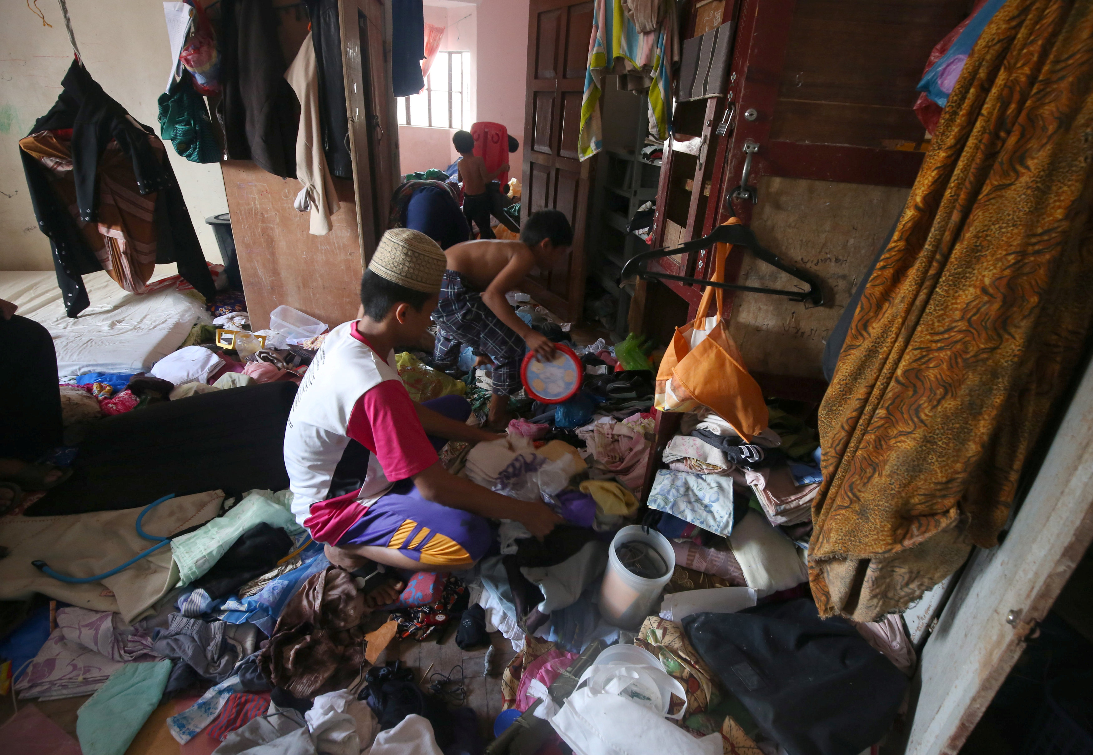 أسرة فلبينية تنظف منزلها عقب عودتها فور خروج داعش من المدينة