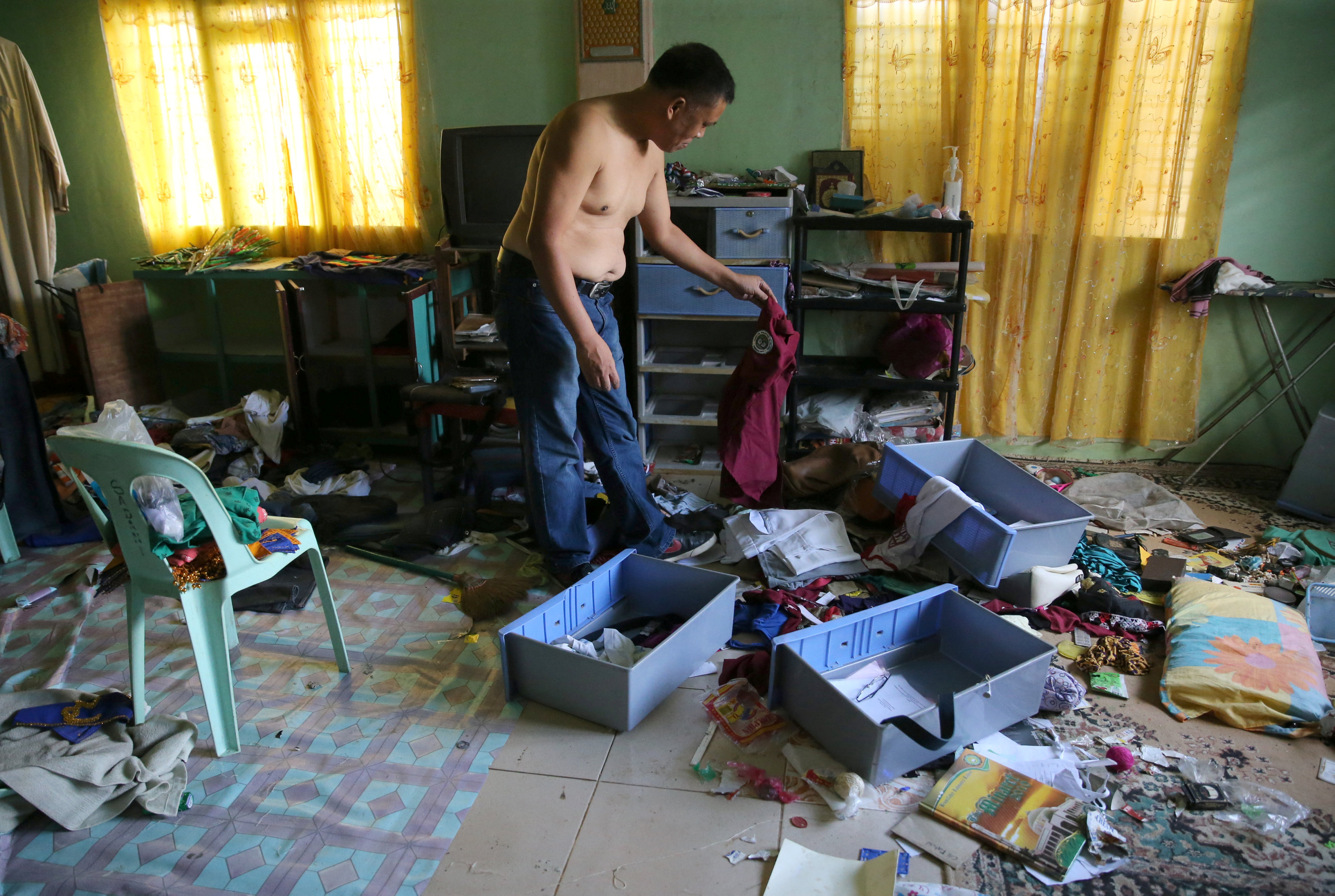 رجل يرتب أغراض منزله فى الفلبين عقب عودته