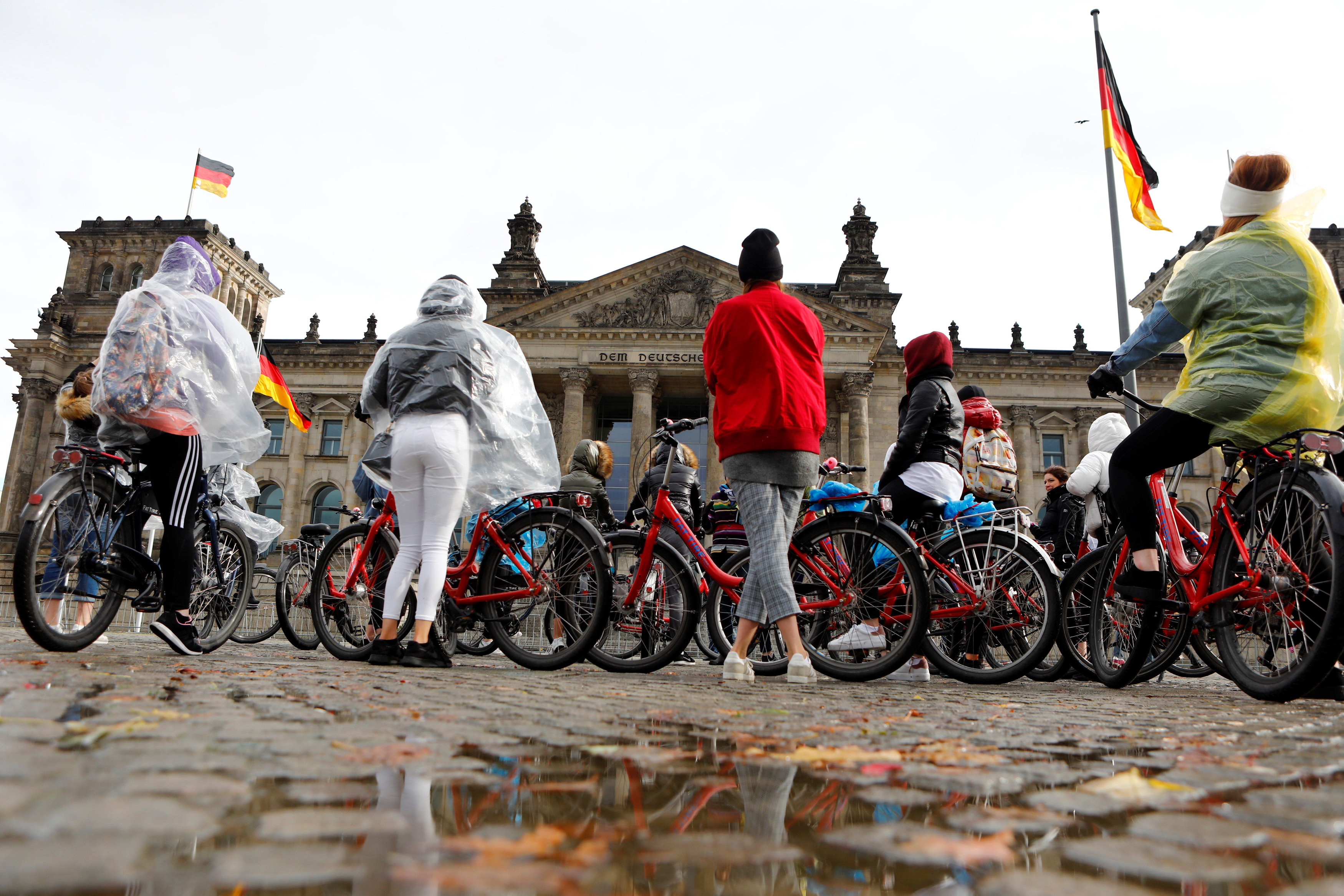 شباب يحتمون برداء بلاستيك من الأمطار فى ألمانيا