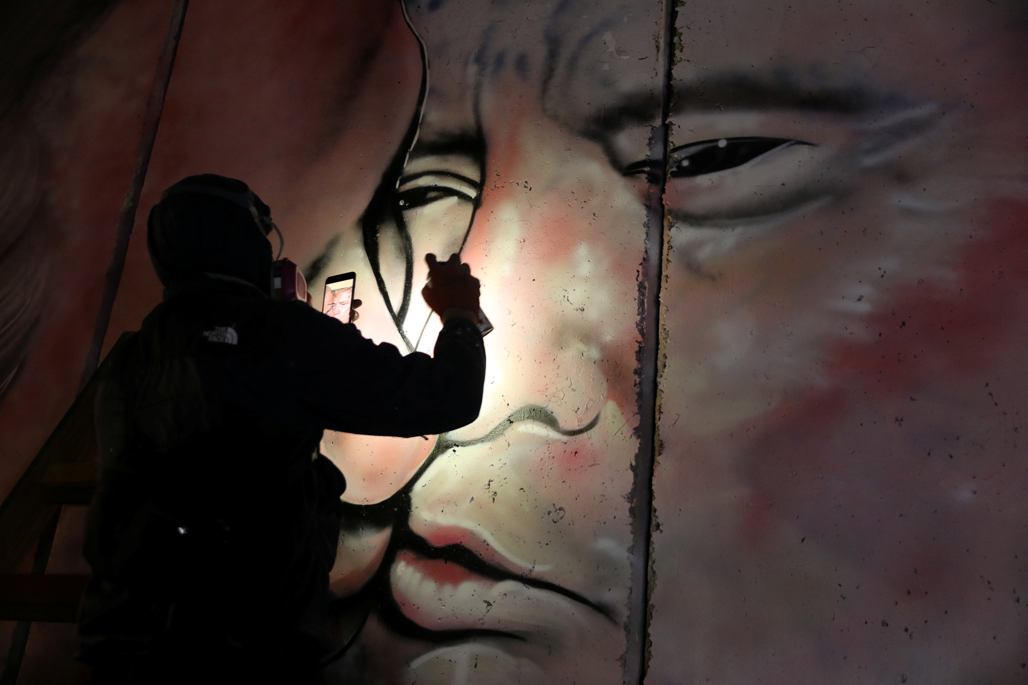 الفنان الأسترالى يستخدم كشاف هاتفه لرسم الجرافيتى