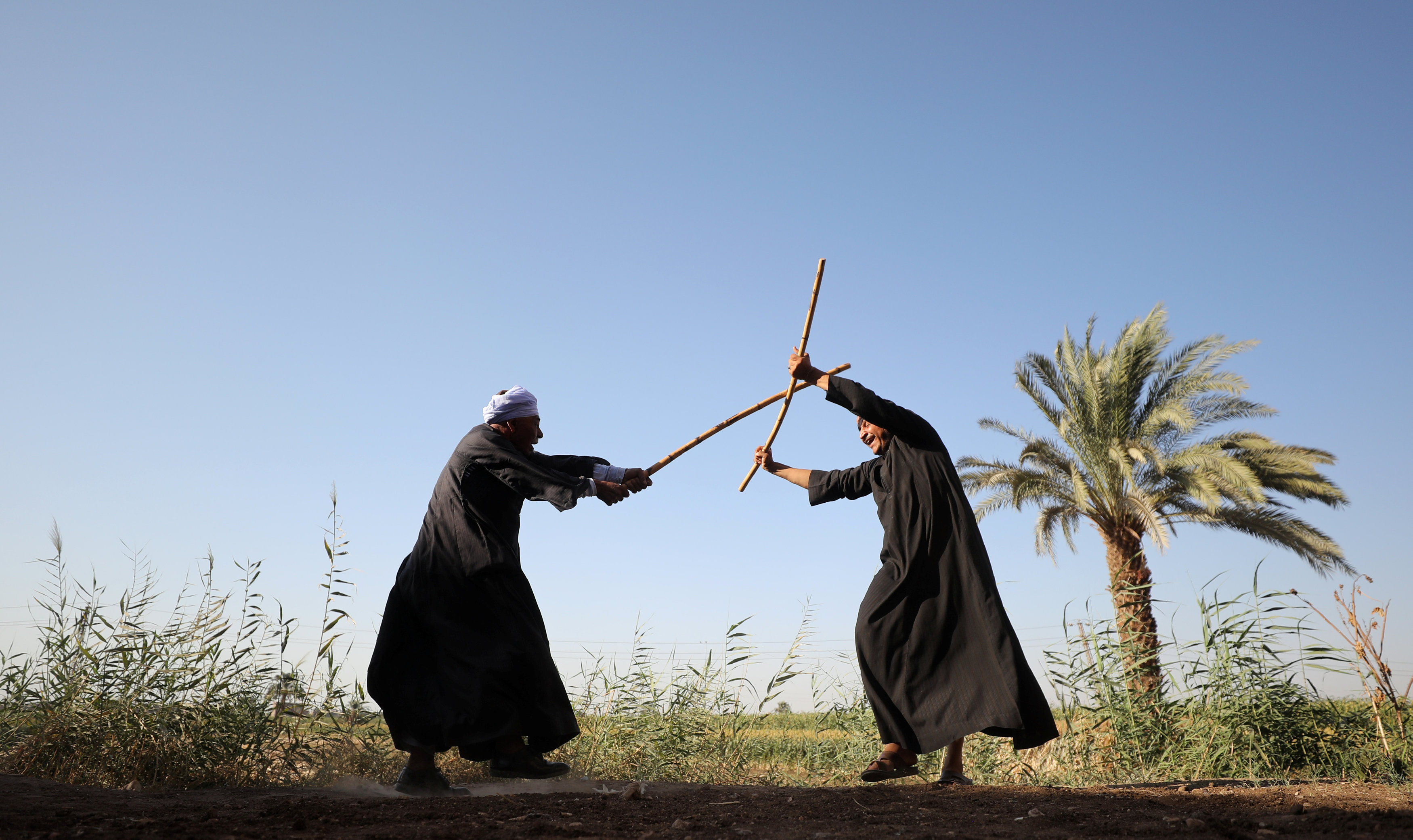 رجلان يمارسان رياضة التحطيب فى صعيد مصر