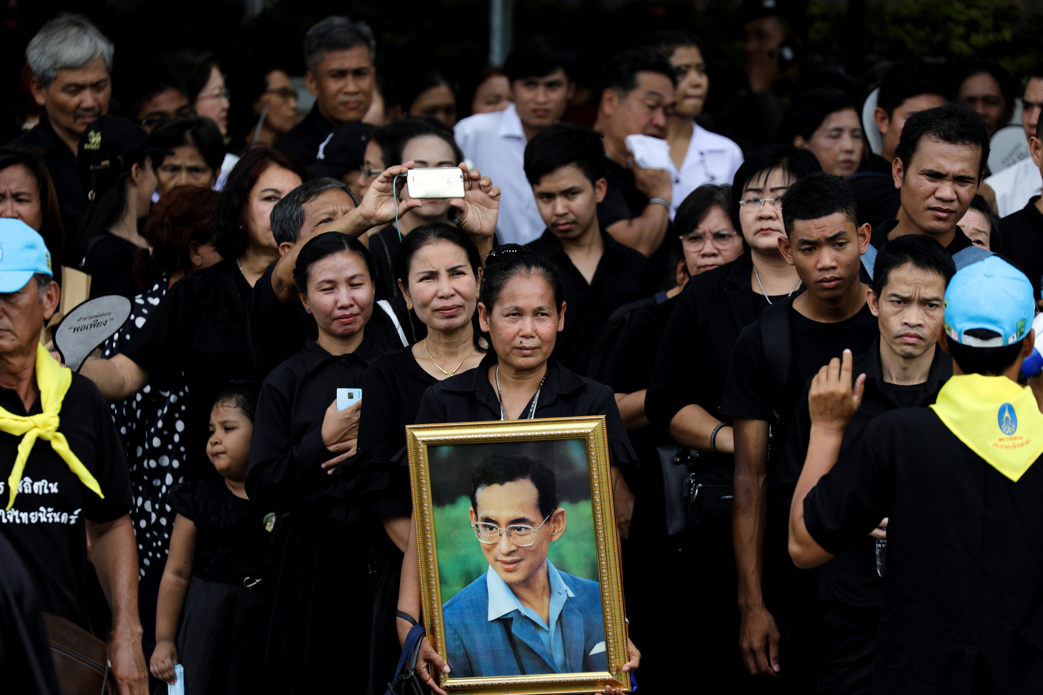 مواطنون يحملون صورة ملك تايلاند الراحل بوميبول أدولياديج