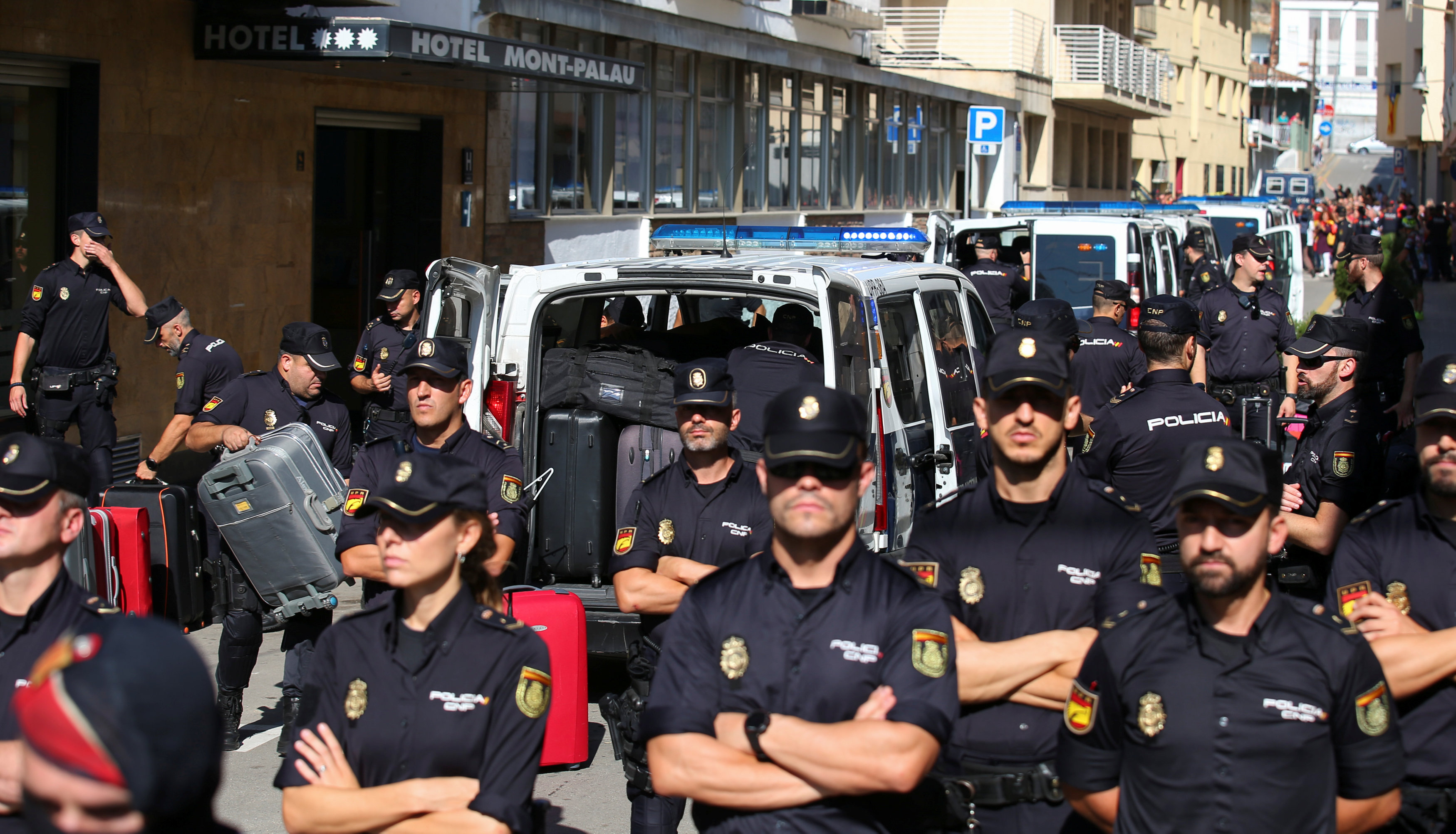 رجال الشرطة الإسبانية يؤمنون زملائهم خلال مغادرة كتالونيا