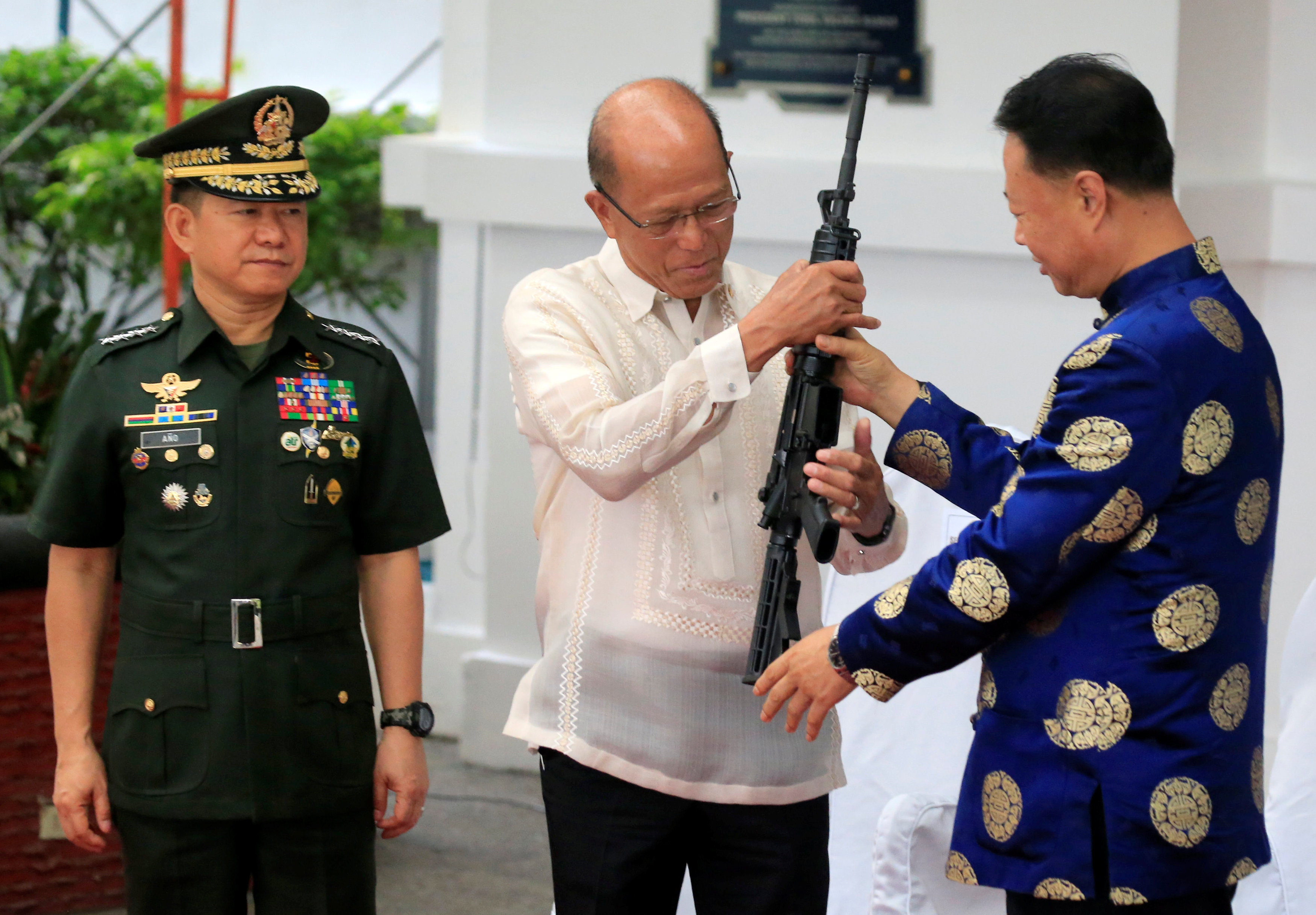 وزير الدفاع الفلبينى يمسك بقطعة سلاح ضمن شحنة صينية ممنوحة لبلاده